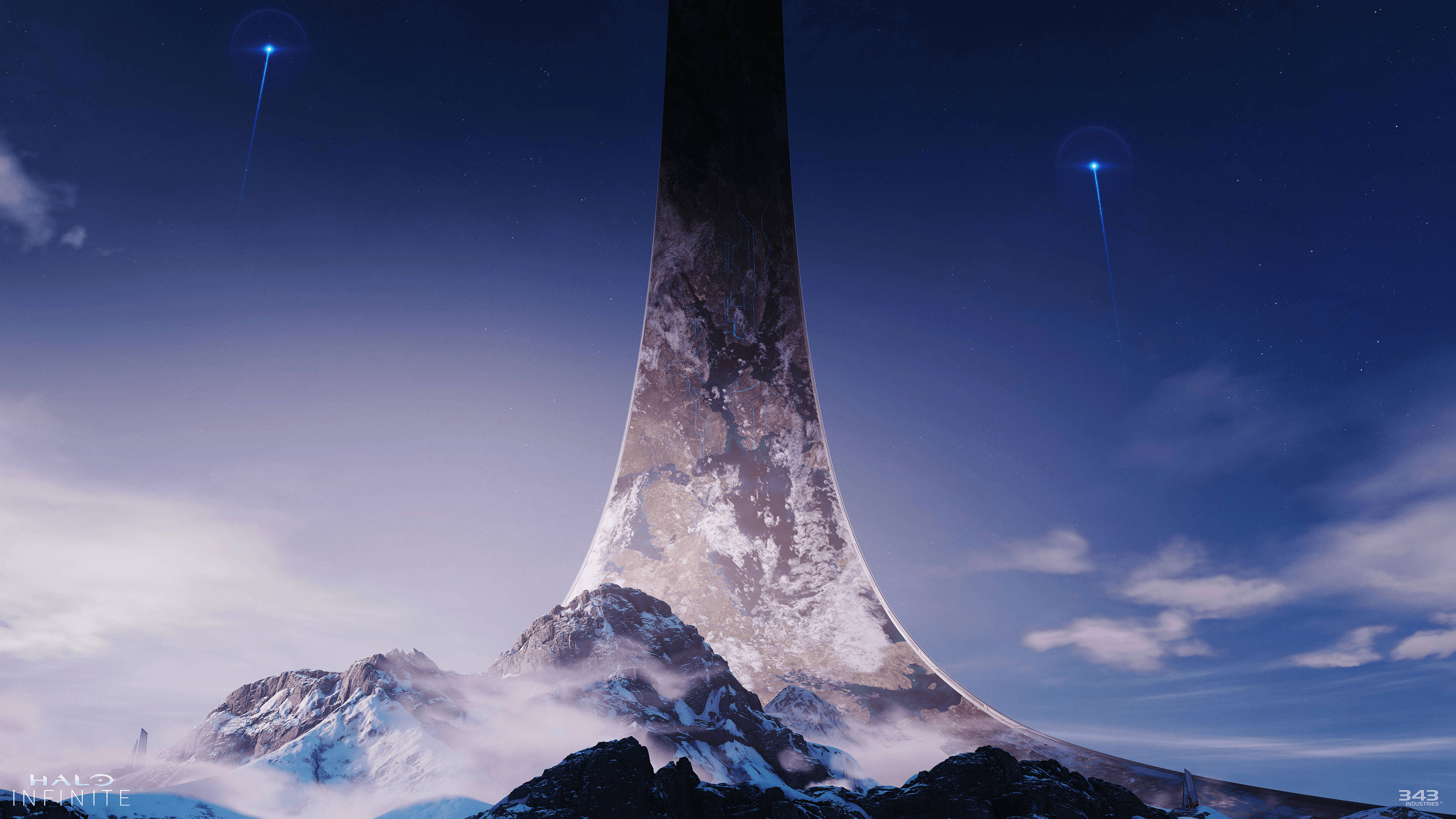 《Halo Infinite》高塔 壁紙 — 一座巨大的單體結構從積雪的山峰中升起，在繁星點點的暮色天空下，伴隨著發光的藍色能量光束。