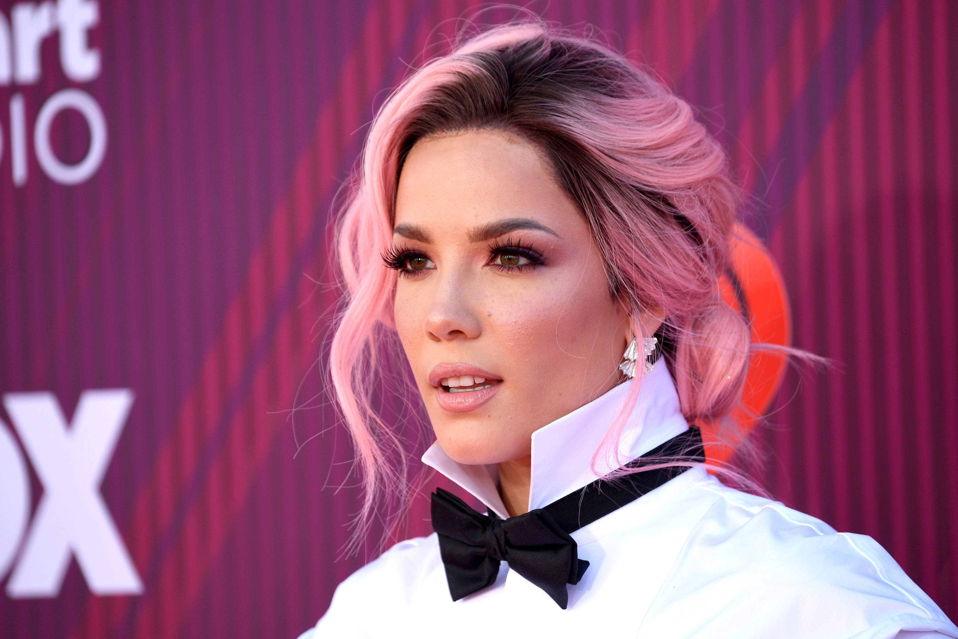 Halsey iHeartRadio音樂獎紅毯 壁紙 — 一位擁有粉紅色頭髮和大膽妝容的女性，在栗色背景前穿著白色襯衫和黑色蝴蝶結領結。