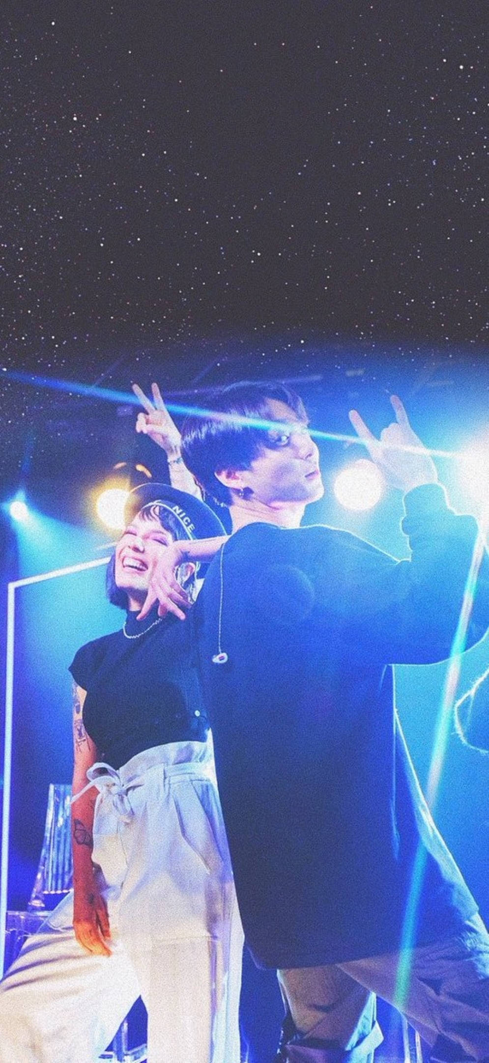 Halsey 與 BTS 洪知秀 合作演出 壁紙 — 兩個人在明亮的藍色舞台燈光下擺出搖滾手勢，背景是星空夜空。