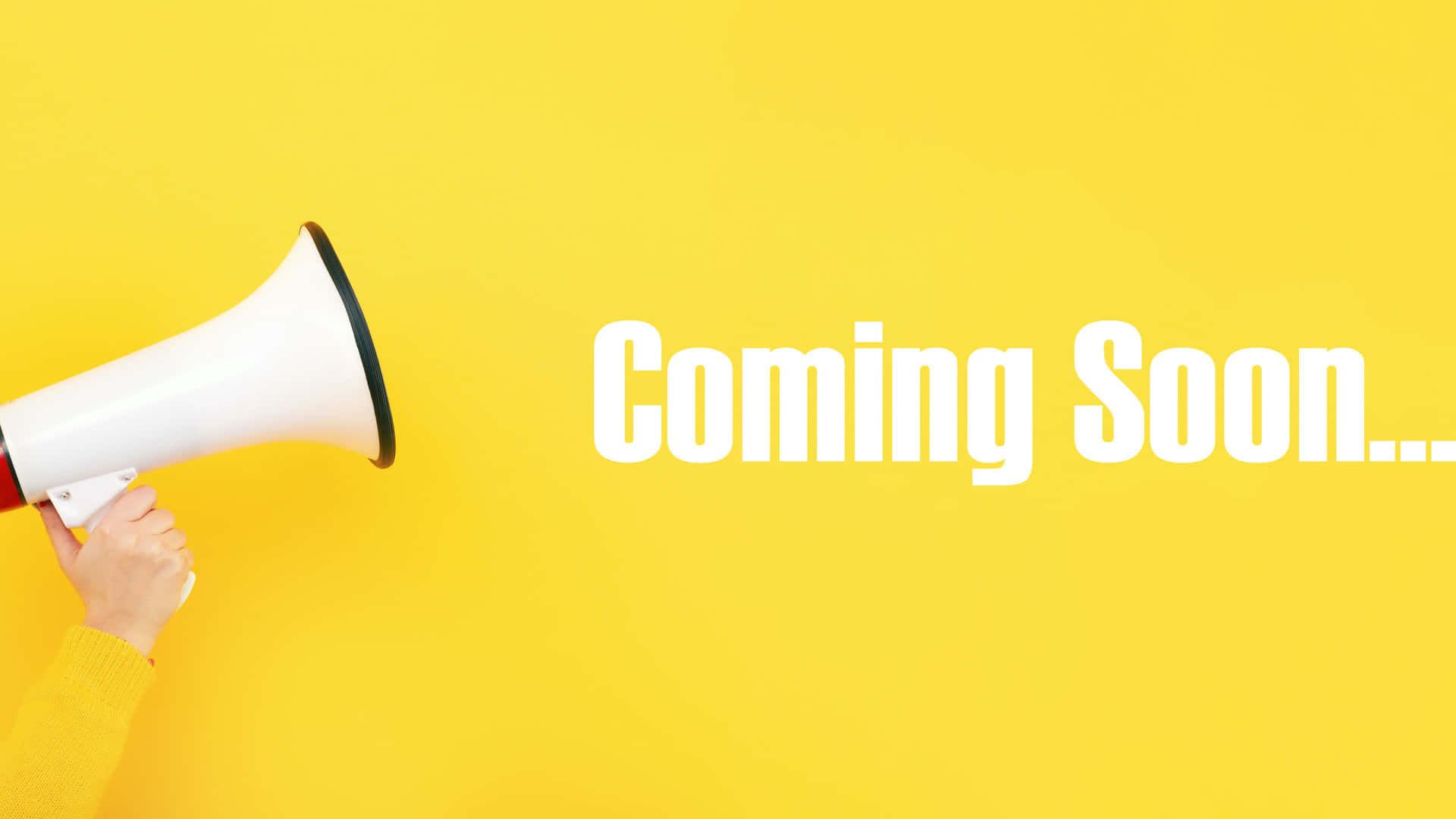 手拿著擴音器，上面有「Coming Soon」文字，背景為黃色