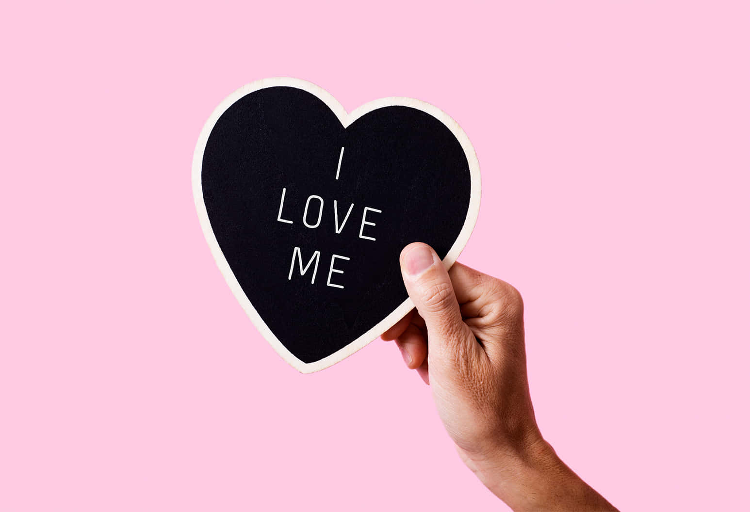 手拿著心形黑板，上面有訊息 I LOVE ME，背景為粉紅色。 — 粉紅色心形動圖 壁紙