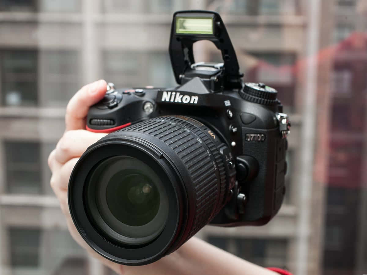 在城市環境中手持Nikon D7100 DSLR相機。