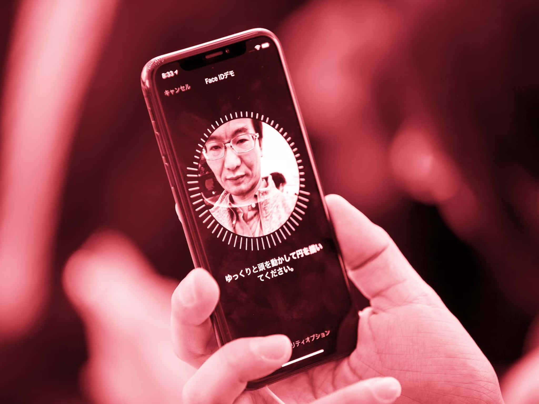 在紅色燈光下進行日本 Face ID 認證時手持電話。