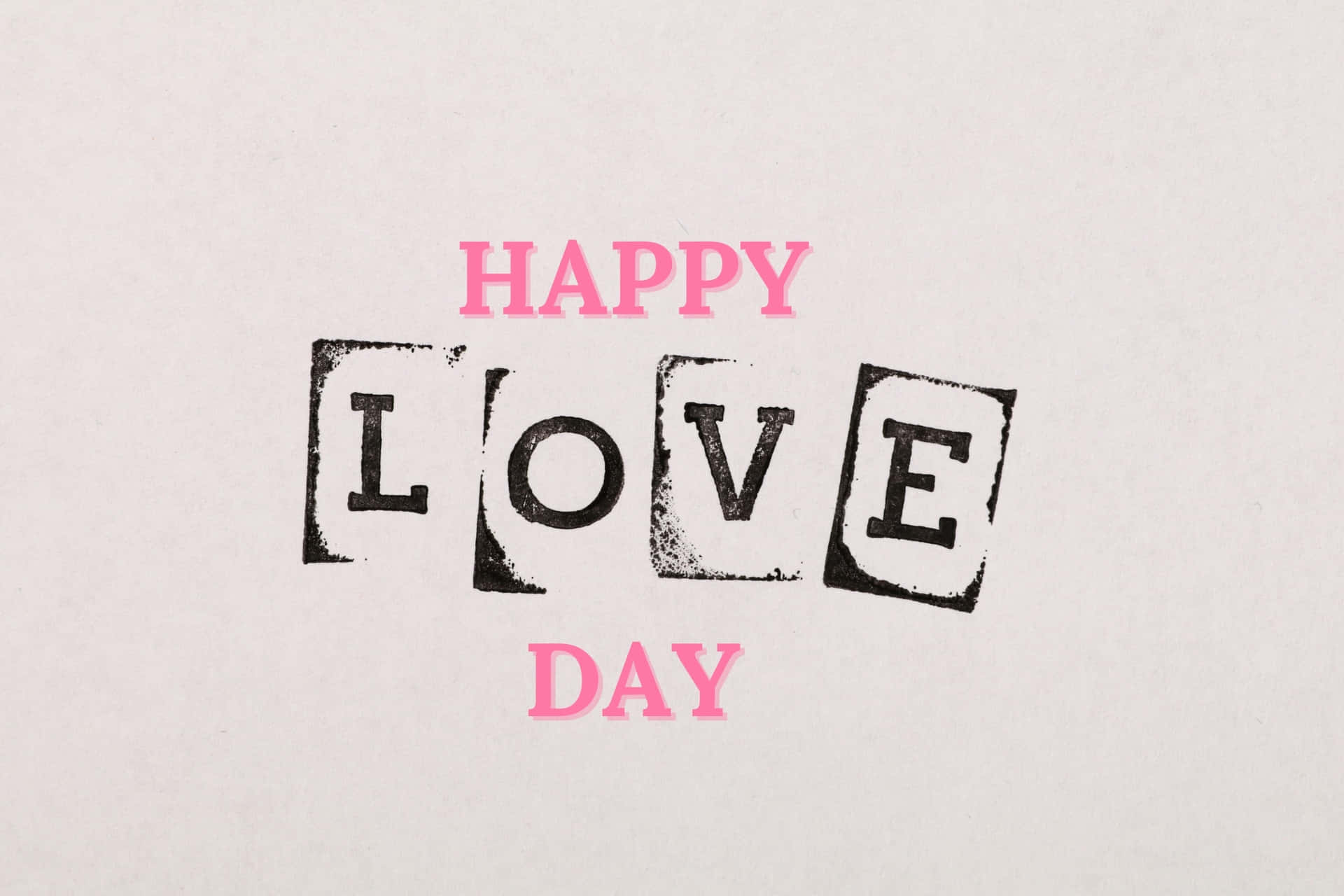  壁紙 — 文字內容為 happy love day，以粉紅色和黑色蓋印字體呈現於有紋理的米白色紙張上。