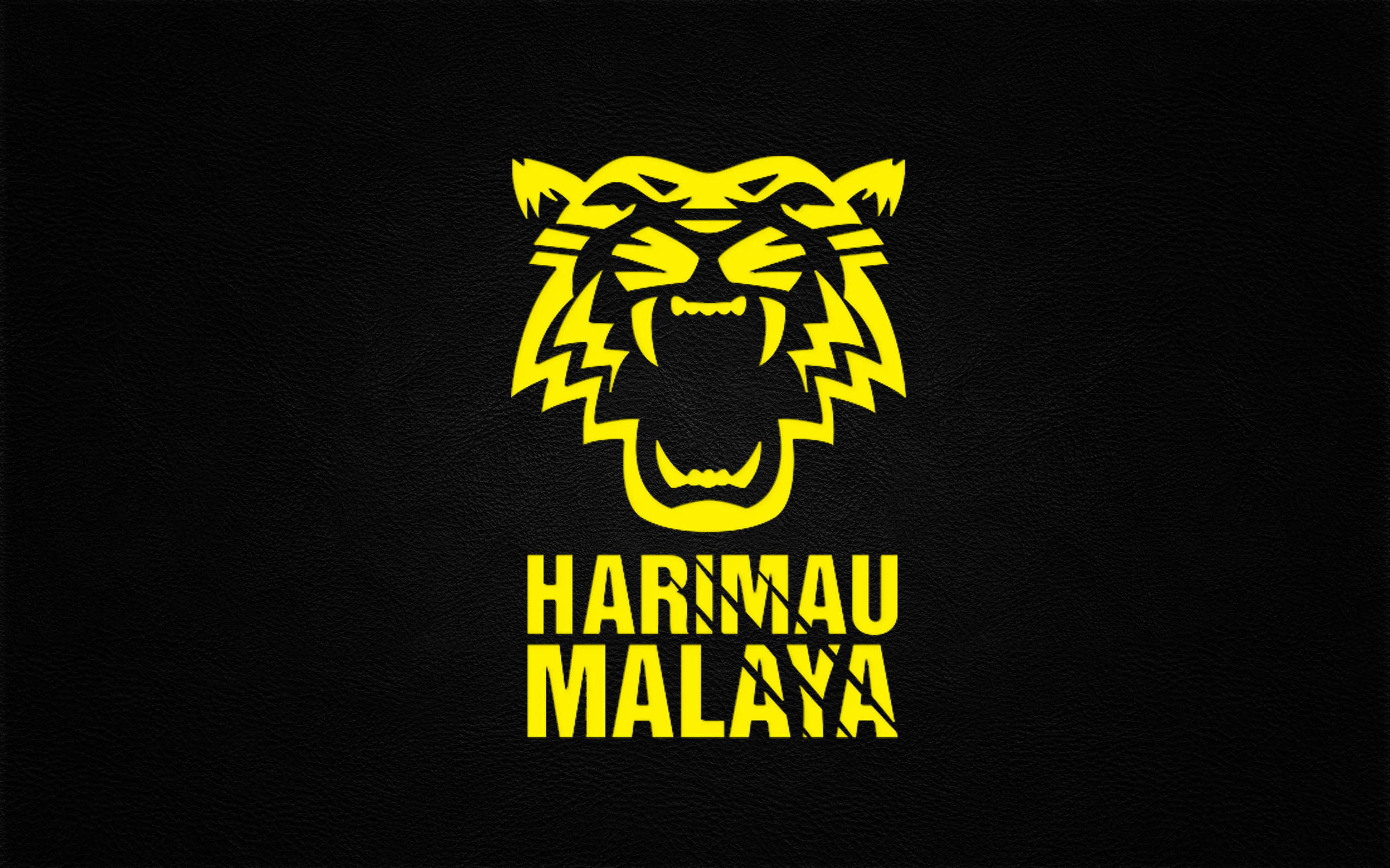 Harimaru Malaya 冷酷足球隊 壁紙 — 一個大膽的黃色風格化虎頭標誌，帶有「HARIMAU MALAYA」文字，位於紋理黑色皮革背景上。