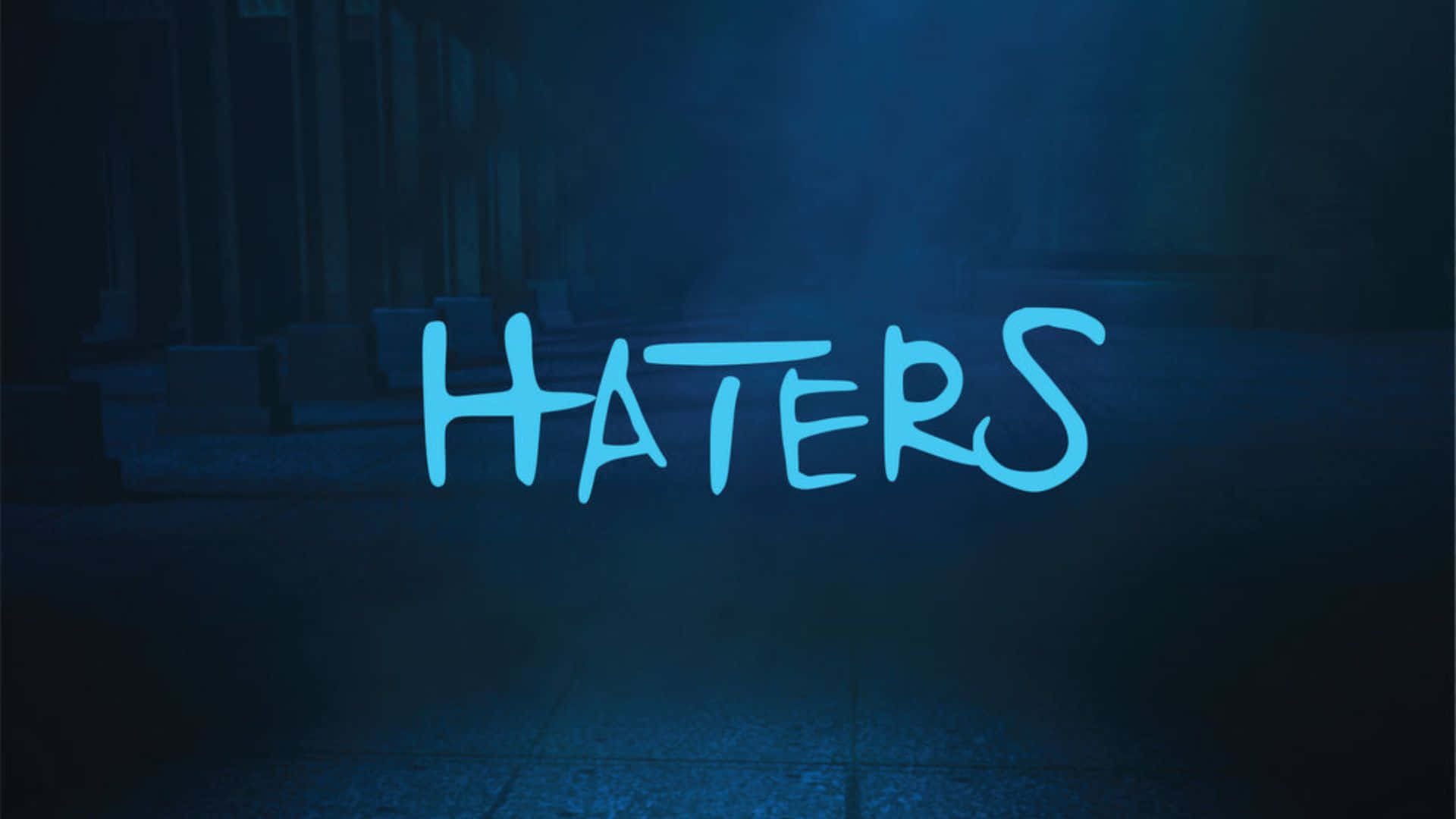  壁紙 — 「HATERS」呢個字喺夜晚一條黑暗、有霧嘅城市後巷入面，以明亮藍色塗鴉風格字體發光。