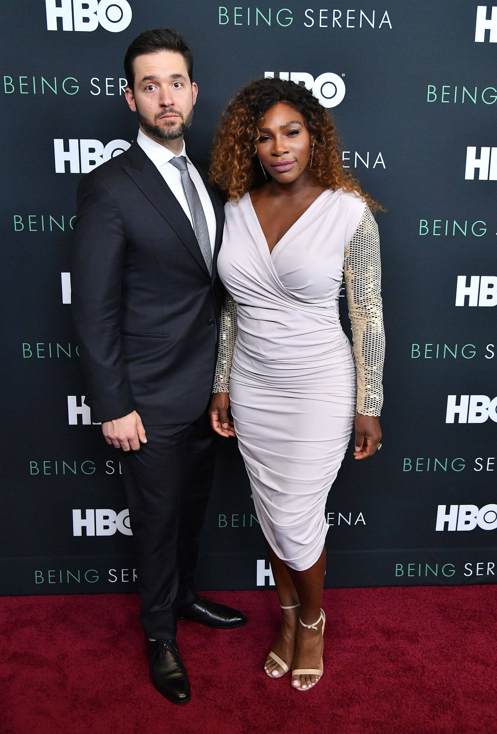 HBO《我是塞雷娜》首映 壁紙 — 塞雷娜·威廉姆斯和她的伴侶在HBO《Being Serena》首映禮的紅地毯上優雅地擺姿勢，背景帶有品牌標誌。
