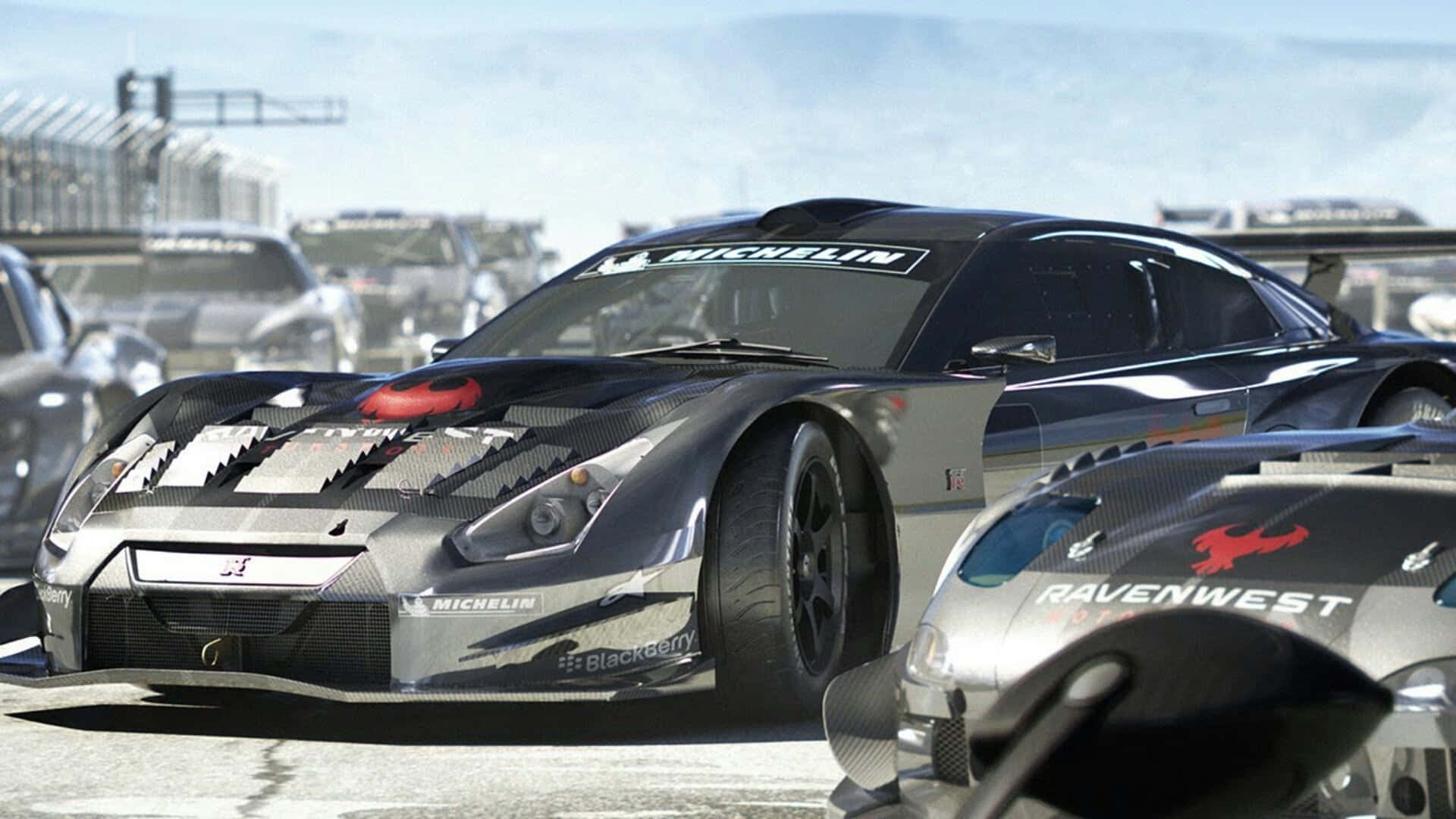 HD Grid Autosport 宣傳影片賽車背景 壁紙 — 一架時尚的黑色賽車，帶有碳纖維細節和米芝蓮品牌標誌，在陽光明媚的賽道上佔據主導地位，背景有其他競爭對手。