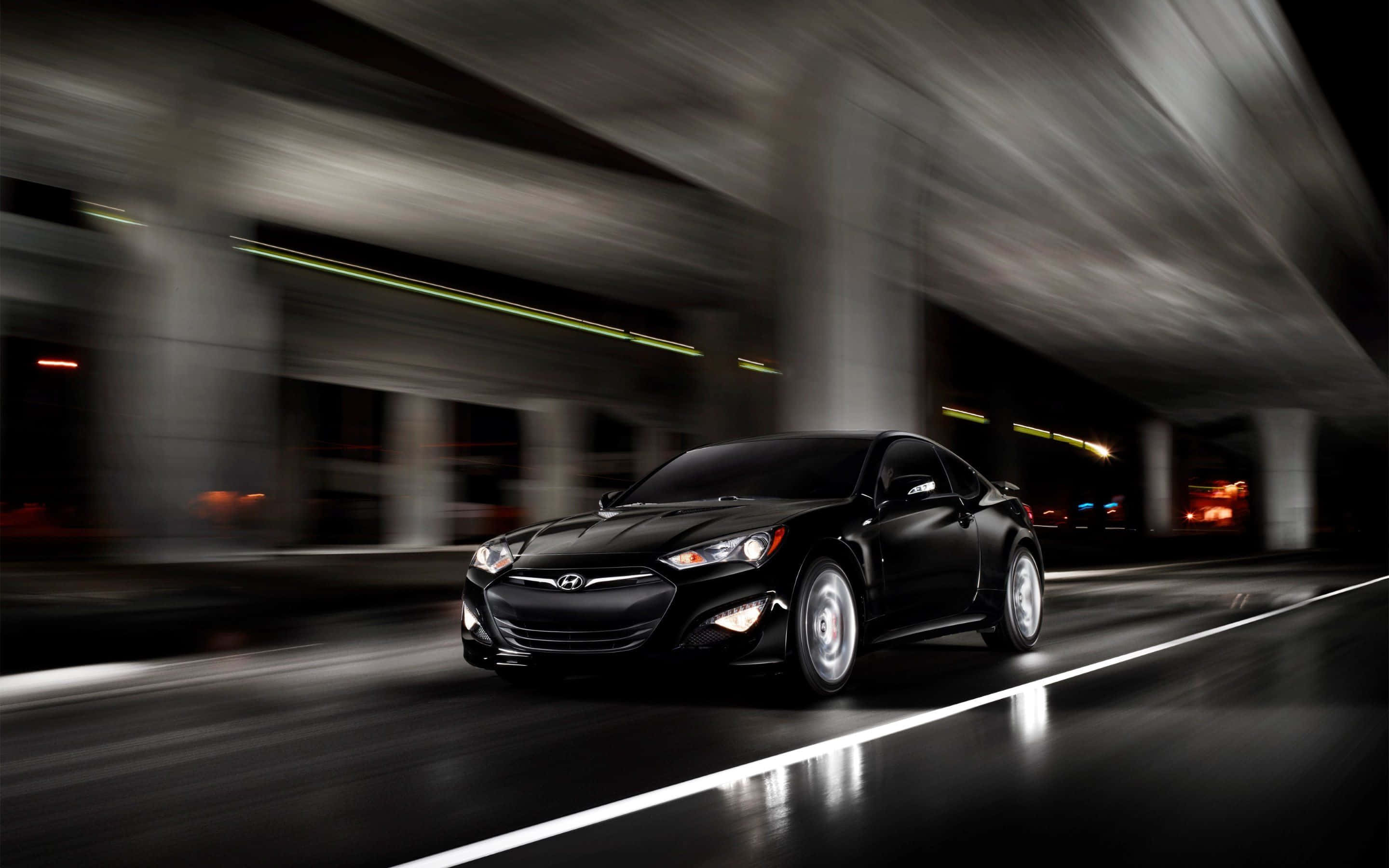 Hyundai Genesis 桌布 壁紙 — 一輛流線型黑色跑車在夜間穿過模糊的城市隧道，帶有發光的車頭燈和濕漉漉的路面反射。