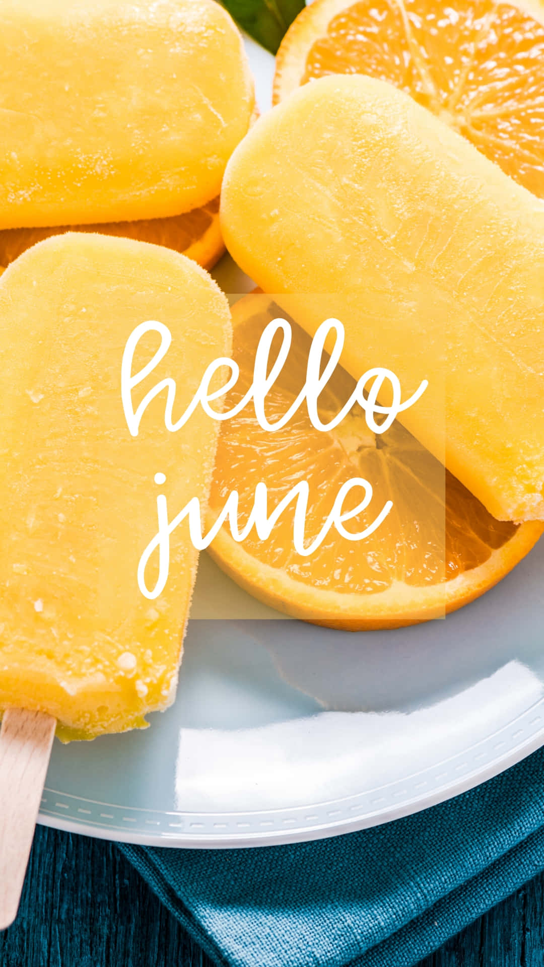 橙色冰棒和柑橘片放在盤子上，搭配青綠色餐巾和hello june文字。