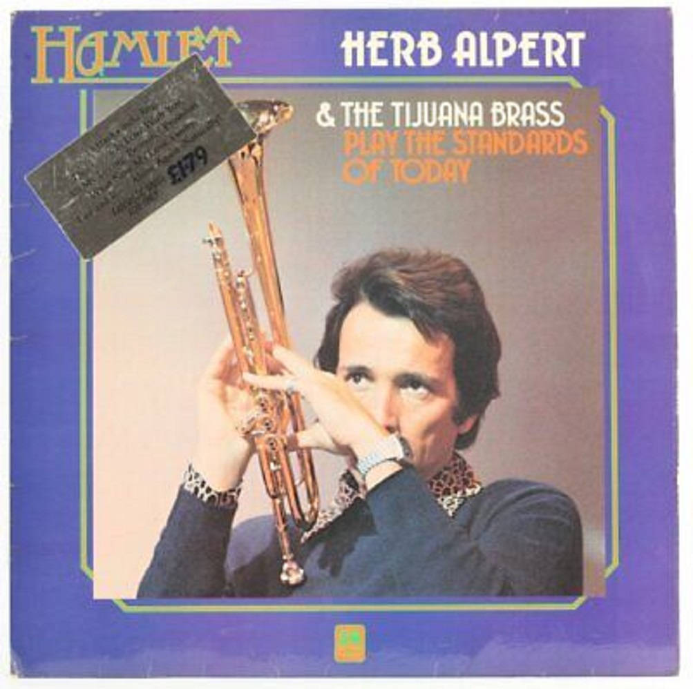Herb Alpert And The Tijuana Brass 古典專輯 壁紙 — 一張復古專輯封面顯示 Herb Alpert 在紫色背景上拿著小號，並配有粗體文字。