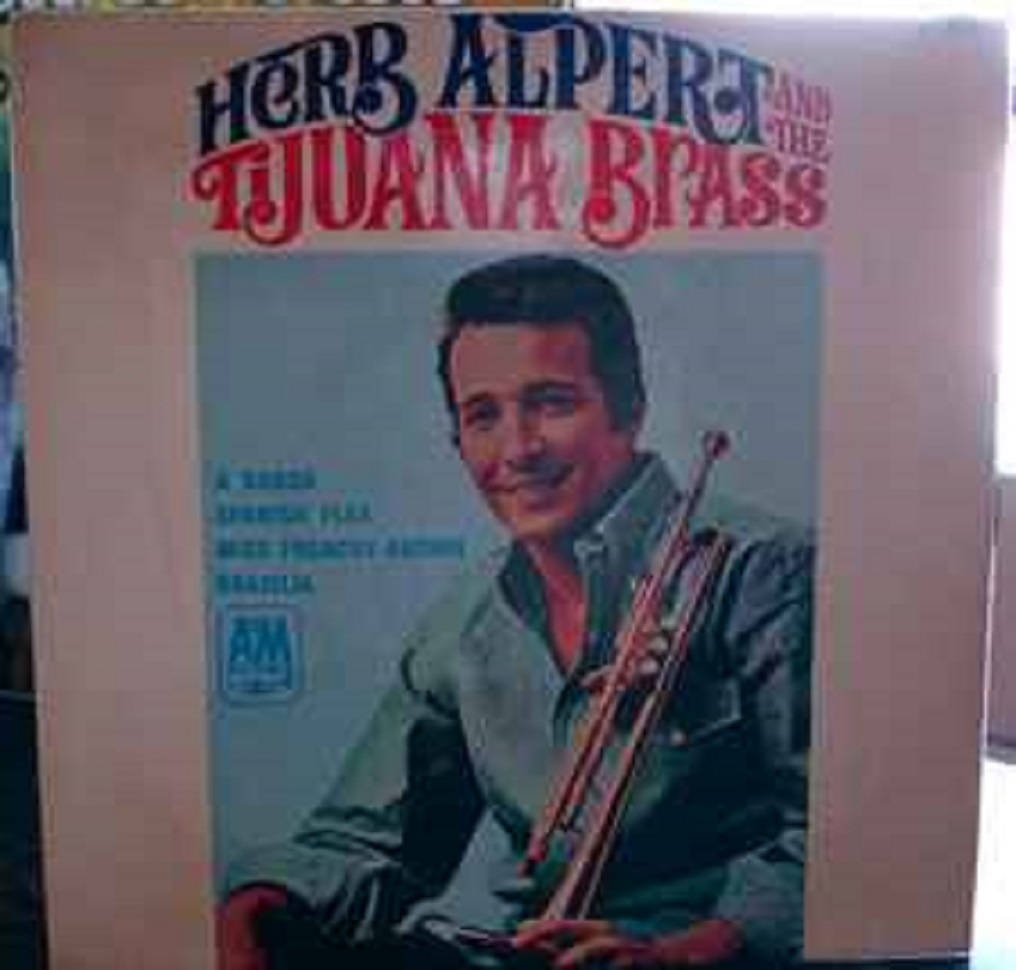 Herb Alpert And The Tijuana Brass 美國樂隊 壁紙 — 復古專輯封面，Herb Alpert 微笑著手持小號，背景為淺藍色。