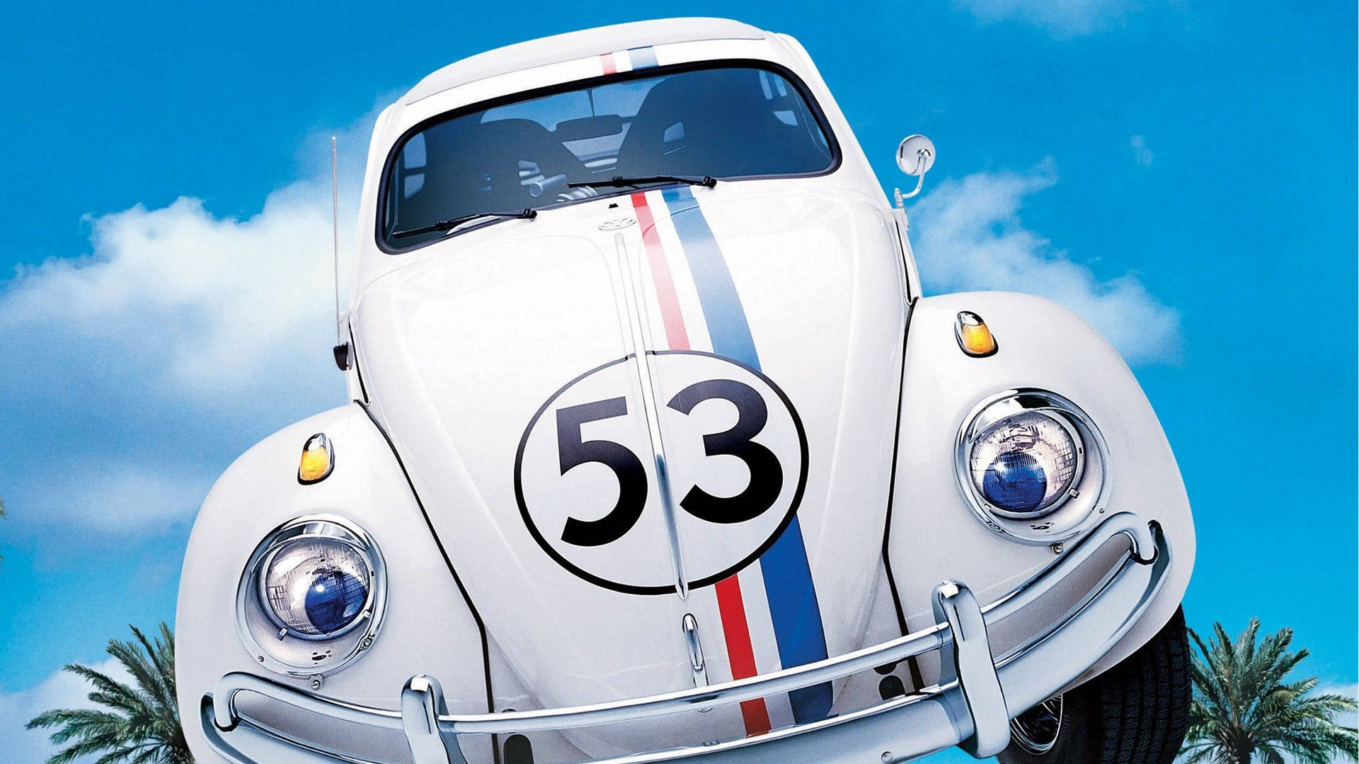 《Herbie：Fully Loaded》微笑特寫壁紙 壁紙 — 一架白色復古福士甲蟲賽車，號碼53，紅藍條紋，背景係藍天白雲同棕櫚樹。