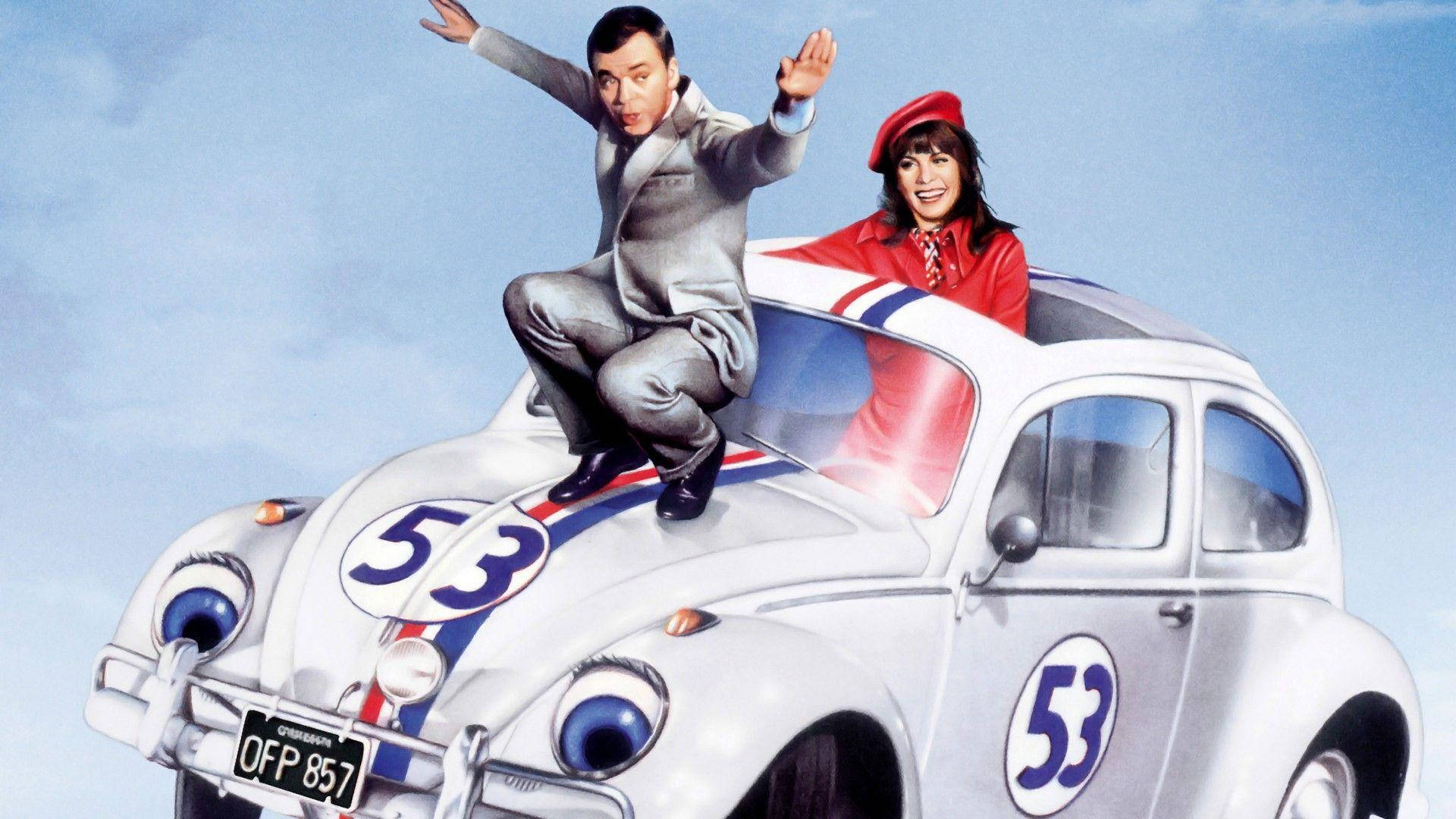 《Herbie Fully Loaded》驚險賽車場景 壁紙 — 一男一女開心地在銀色賽車上擺姿勢，賽車有卡通眼睛和53號，背景是晴朗的藍天。