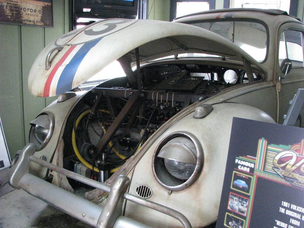 《Herbie：Fully Loaded》引擎蓋打開壁紙 壁紙 — 一輛1961年經典福士甲蟲賽車，在博物館車庫內打開引擎蓋，露出改裝引擎。
