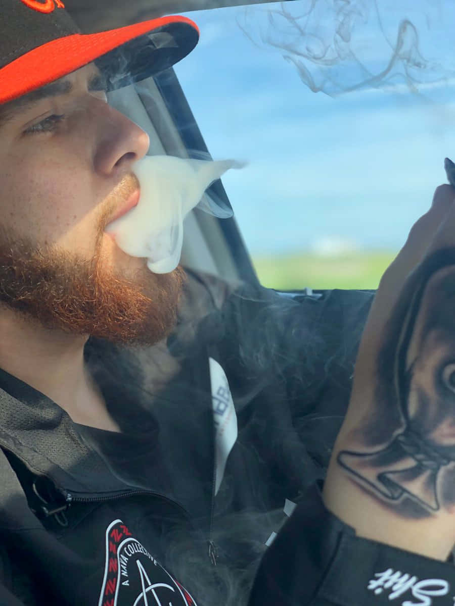 紅鬍鬚男人在日間於車內呼出蒸氣。