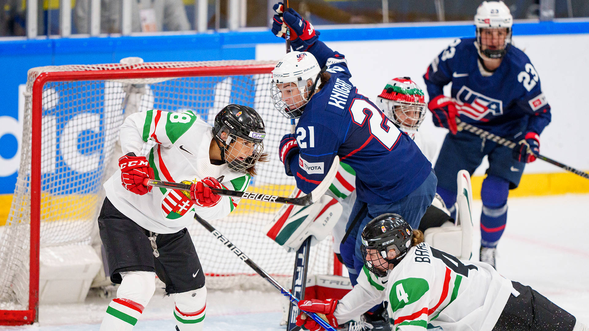 Hilary Knight 勝利瞬間動作照 壁紙 — 激烈的女子冰球運動員在比賽中於球門附近爭奪冰球。