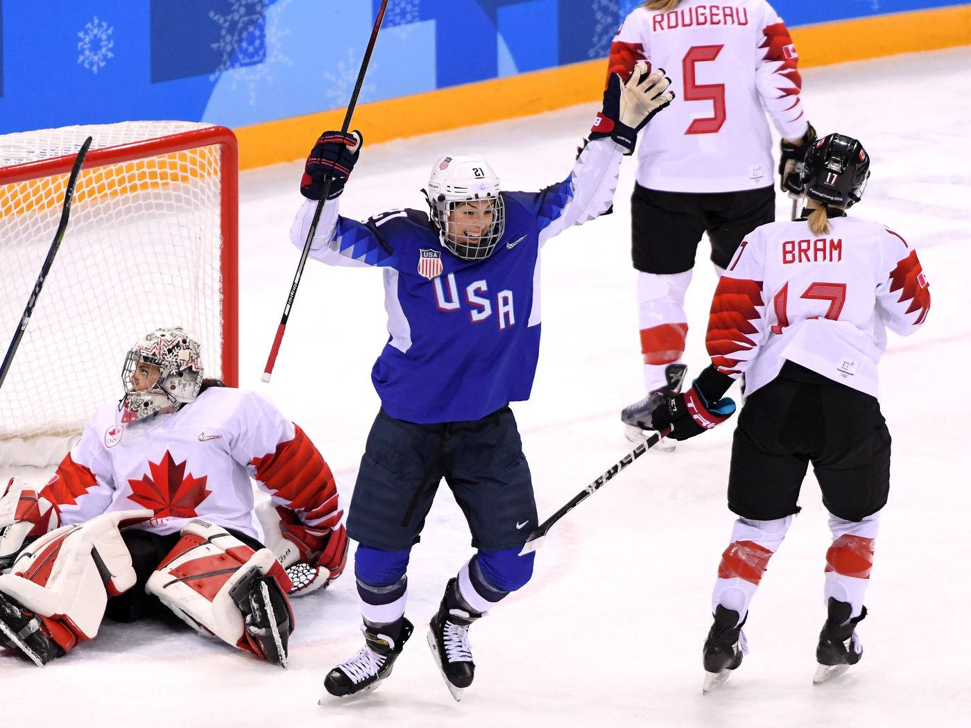 Hilary Knight 奧運賽場英姿 壁紙 — 美國冰球運動員高舉雙臂慶祝入球，加拿大守門員倒在冰上。