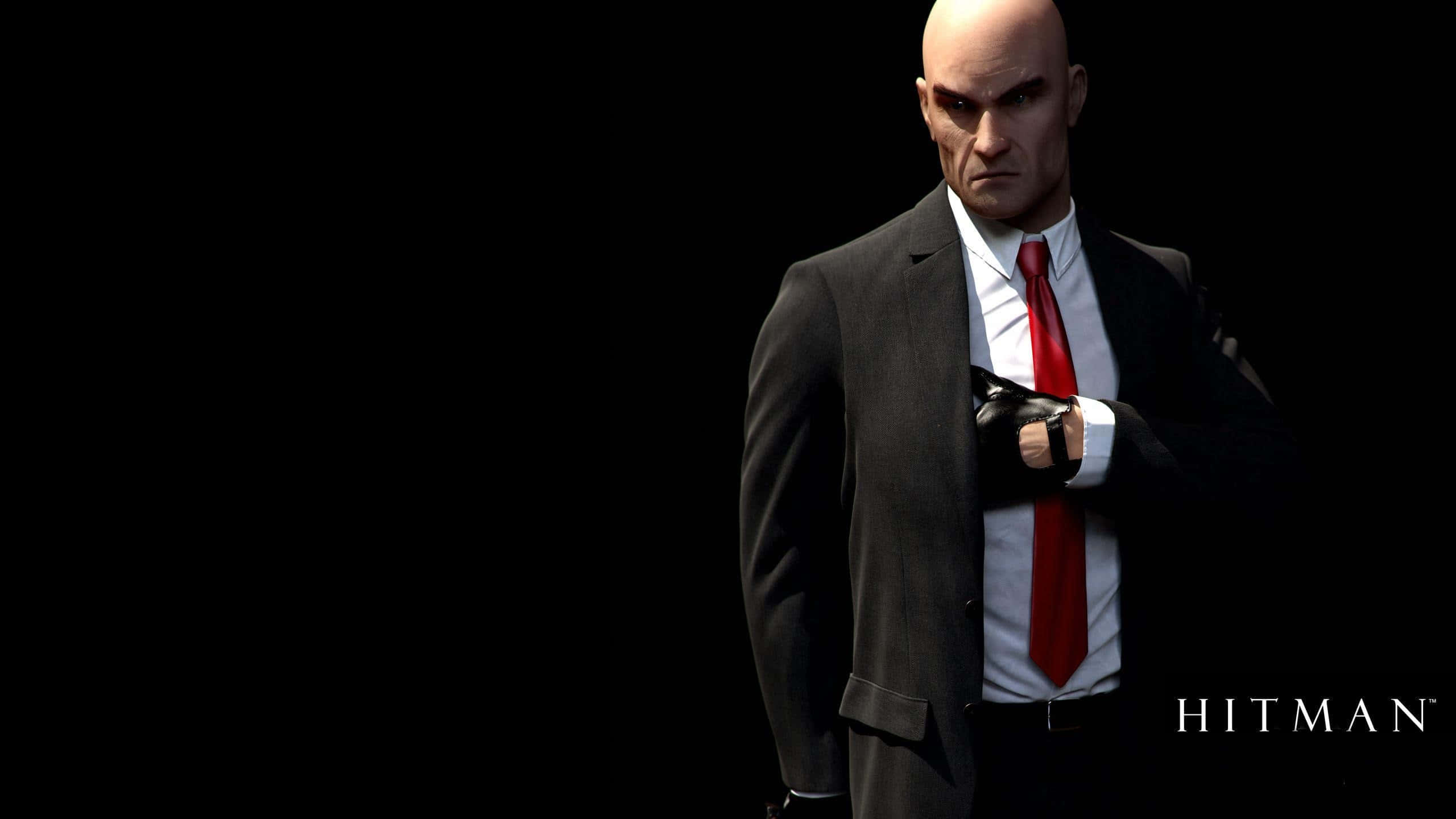 Hitman Blood Money：特工47於黑暗中 壁紙 — 一個光頭男人穿著深色西裝和紅色領帶，站在黑色背景前，表情嚴肅。