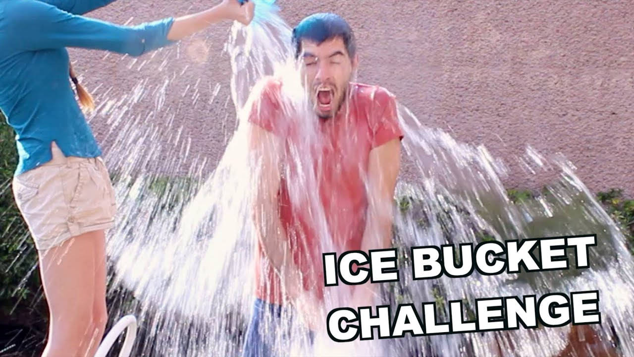 HolaSoyGerman 參與冰桶挑戰 壁紙 — 一個人在冰桶挑戰中戲劇性地反應，另一個人將冰水倒在其頭上。