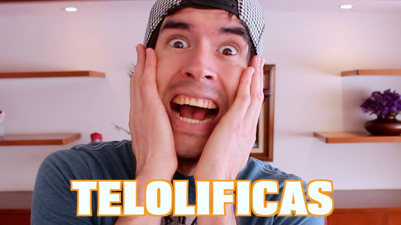 HolaSoyGerman YouTube 封面 壁紙 — 一個睜大眼睛、雙手放在臉頰上的男人在一個光線明亮、有木架和紫色花朵的房間裡開心地尖叫。