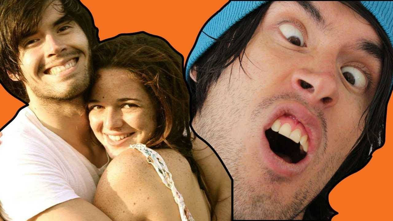 HolaSoyGerman 拥抱女孩 壁紙 — 一名男子和一名女子溫暖地微笑，而第三名戴著藍色冷帽的男子在鮮橙色背景前做出震驚的表情。