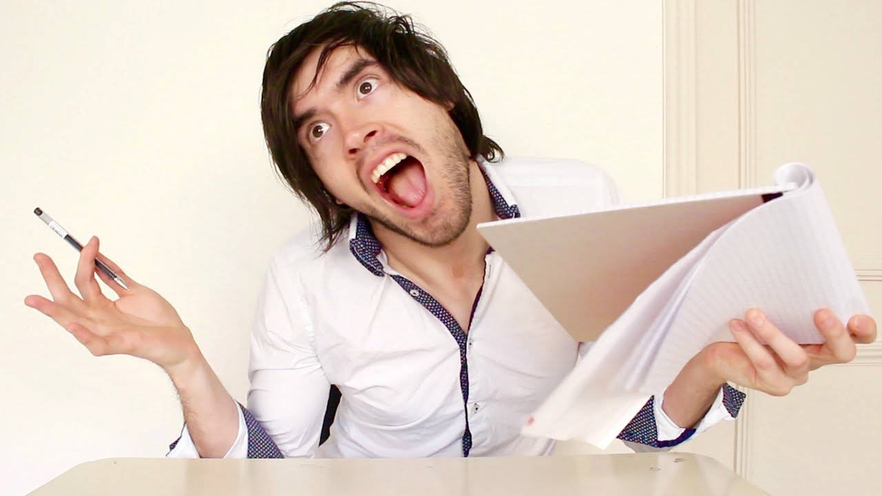 HolaSoyGerman 長髮造型 壁紙 — 一名身穿白恤衫的男子在書桌前拿著筆記本和筆，驚恐地尖叫。
