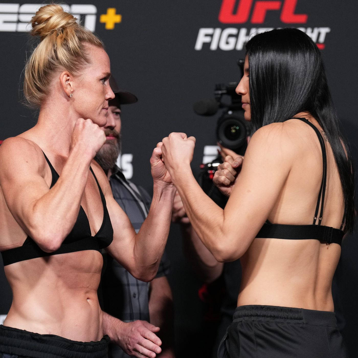 Holly Holm 與 Ketlen Vieira 對峙 壁紙 — 兩位女性UFC拳手在明亮的攝影棚燈光下，於緊張的賽前對峙中鎖住拳頭。