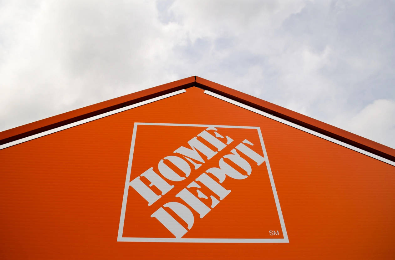 Home Depot 橙色倉庫標誌 壁紙 — 低角度拍攝Home Depot商店標誌性的橙色屋頂，帶有白色標誌，背景為多雲天空。