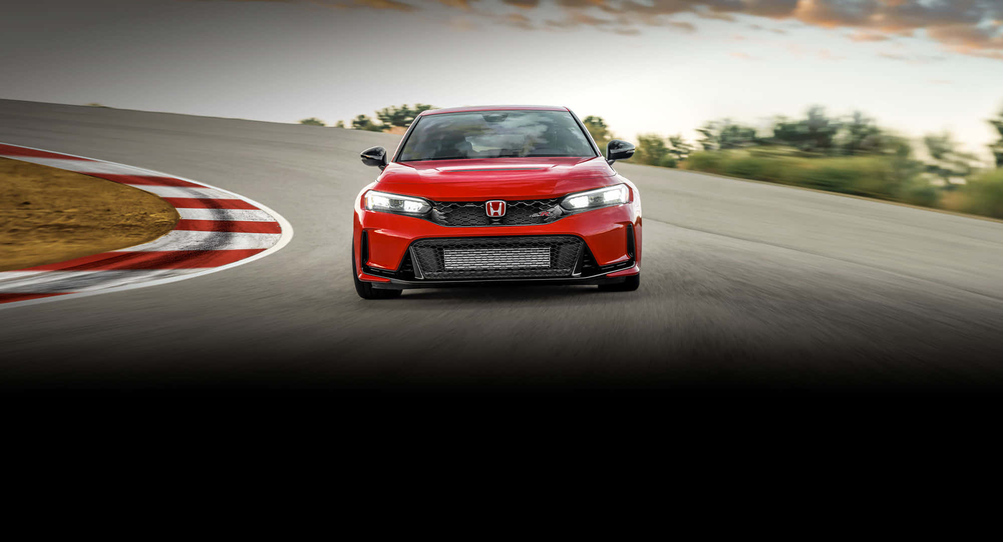 極致攻勢的 Honda Civic Type R 壁紙 — 一輛鮮紅色的本田思域Type R在彎曲的賽道上奔馳，帶有動態模糊和日落光線。
