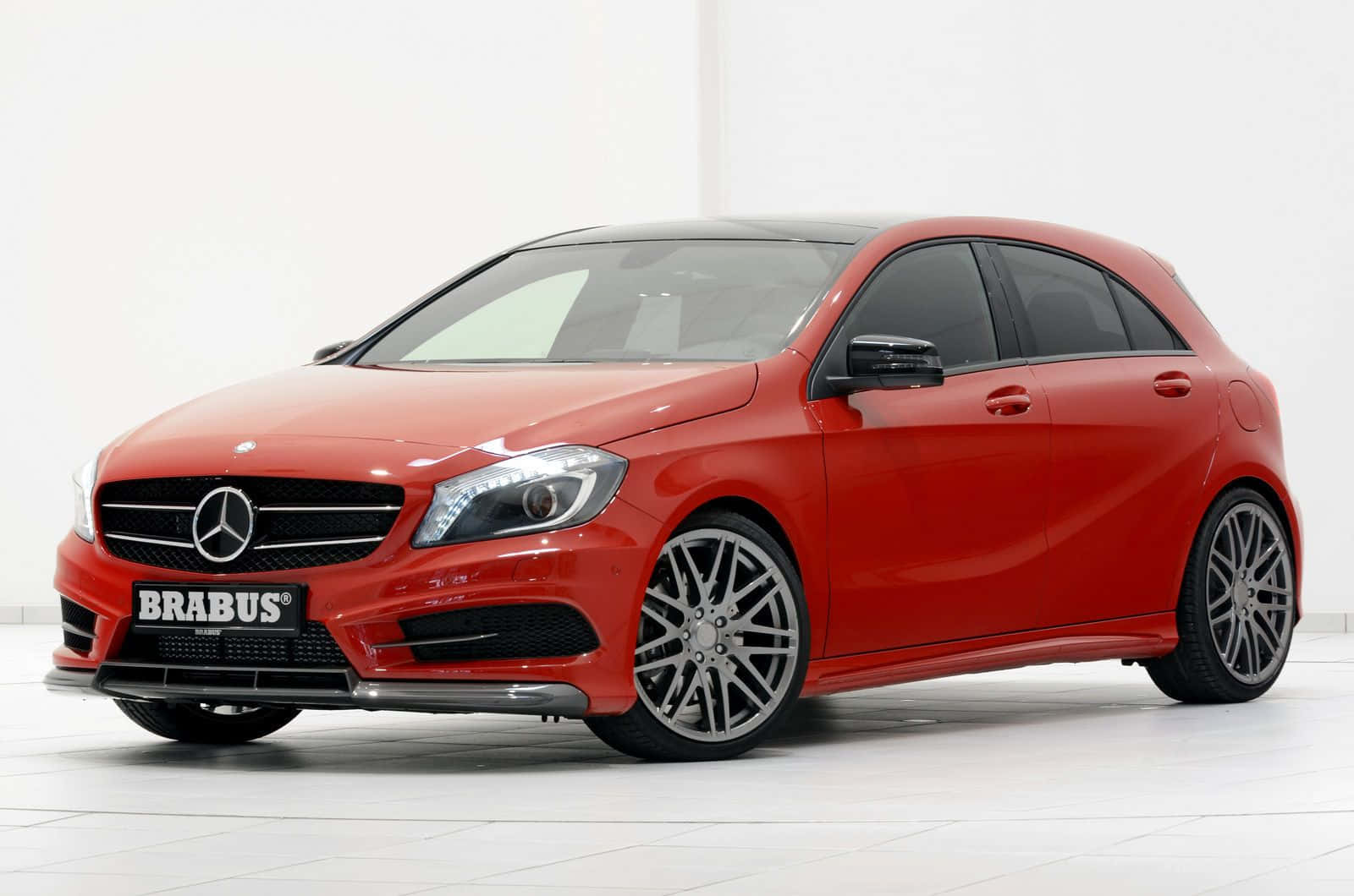 Mercedes Benz A-class 桌布 壁紙 — 一輛鮮紅色的Brabus改裝Mercedes A-Class掀背車在白色瓷磚地板上，在明亮的攝影棚燈光下閃閃發光。