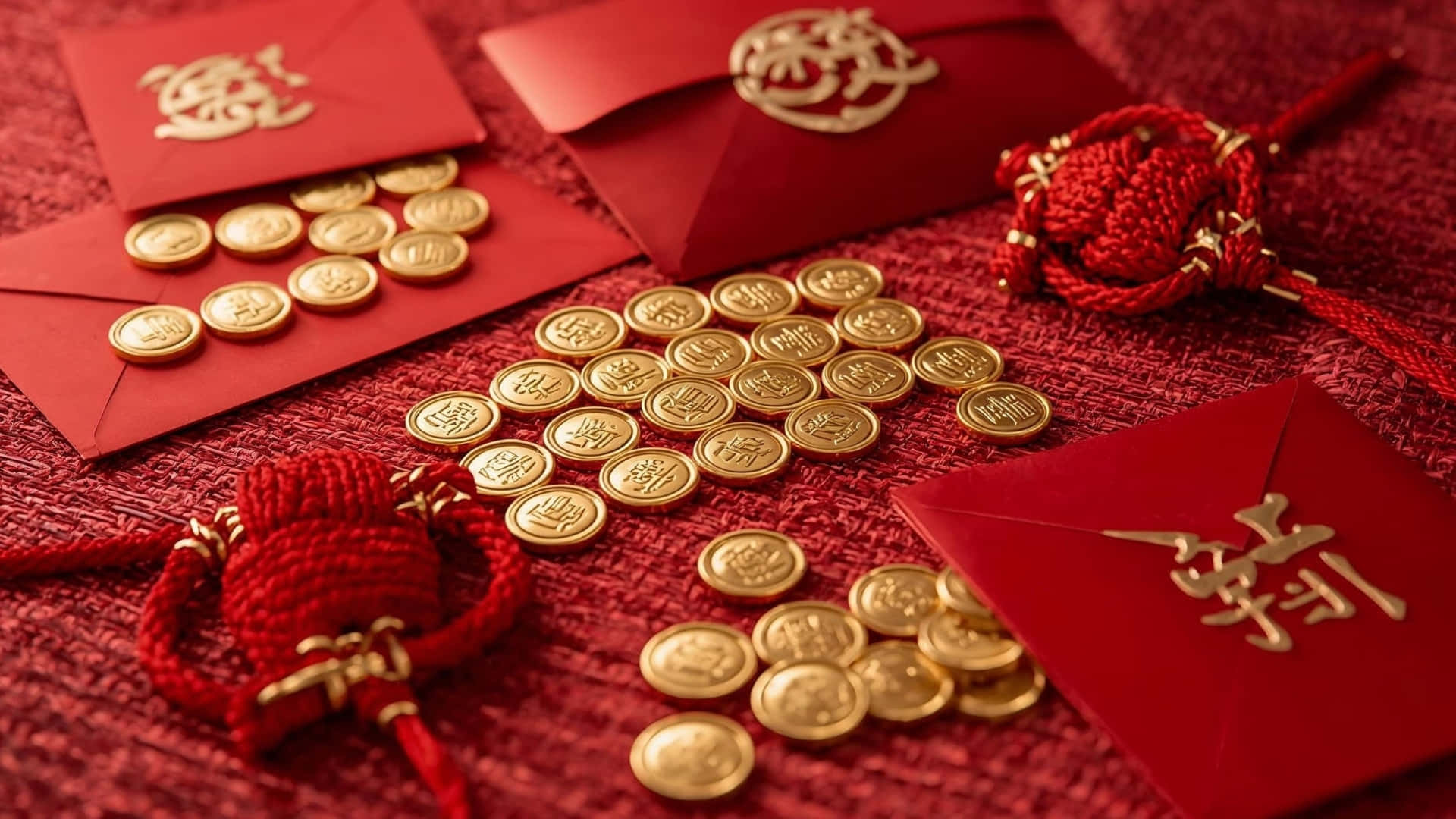  壁紙 — 紅色利是封和金幣排列在帶有紋理的紅色布料上，慶祝農曆新年。