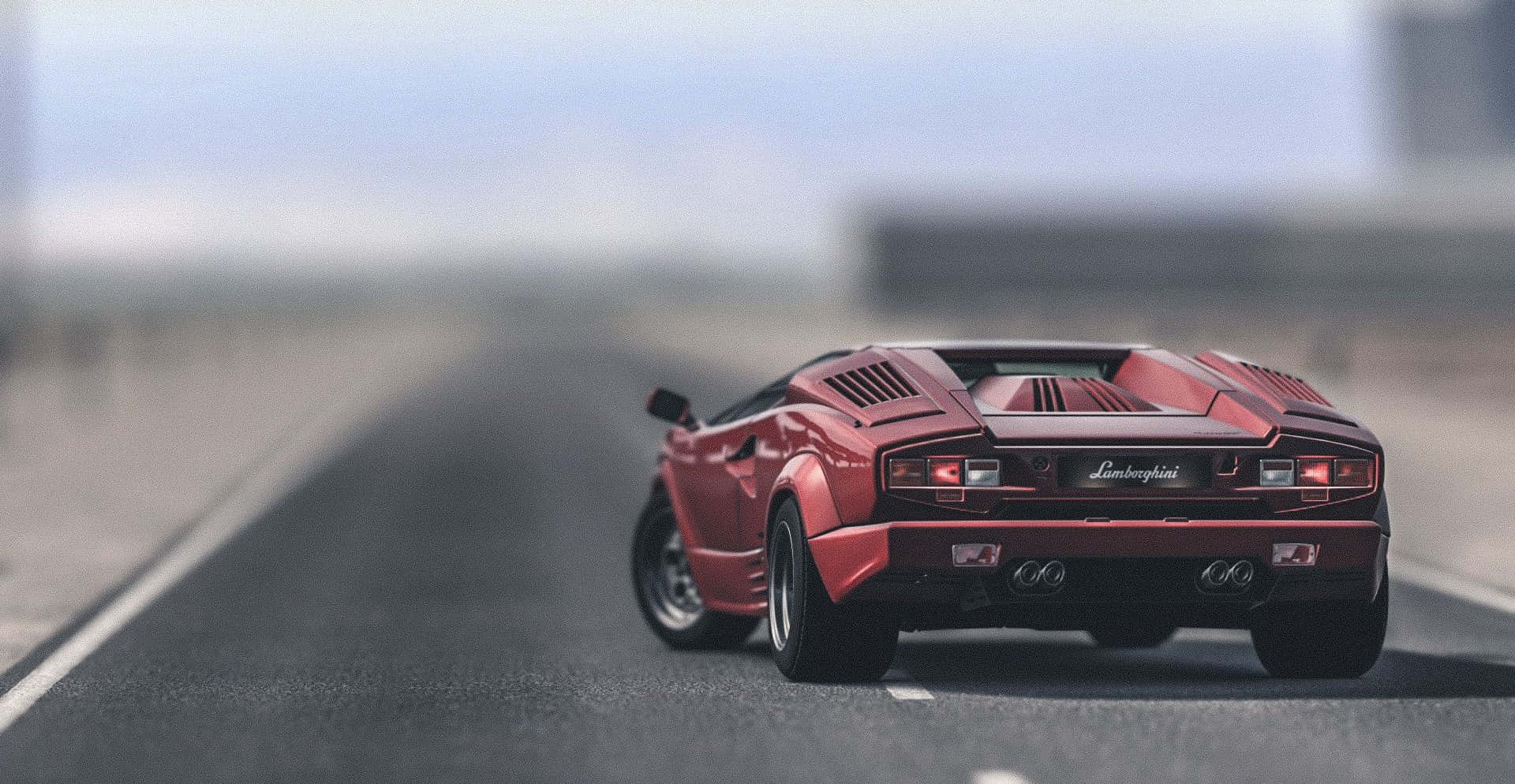 Lamborghini Countach 桌布 壁紙 — 一輛紅色林寶堅尼跑車在模糊的高速公路上行駛，天空朦朧。