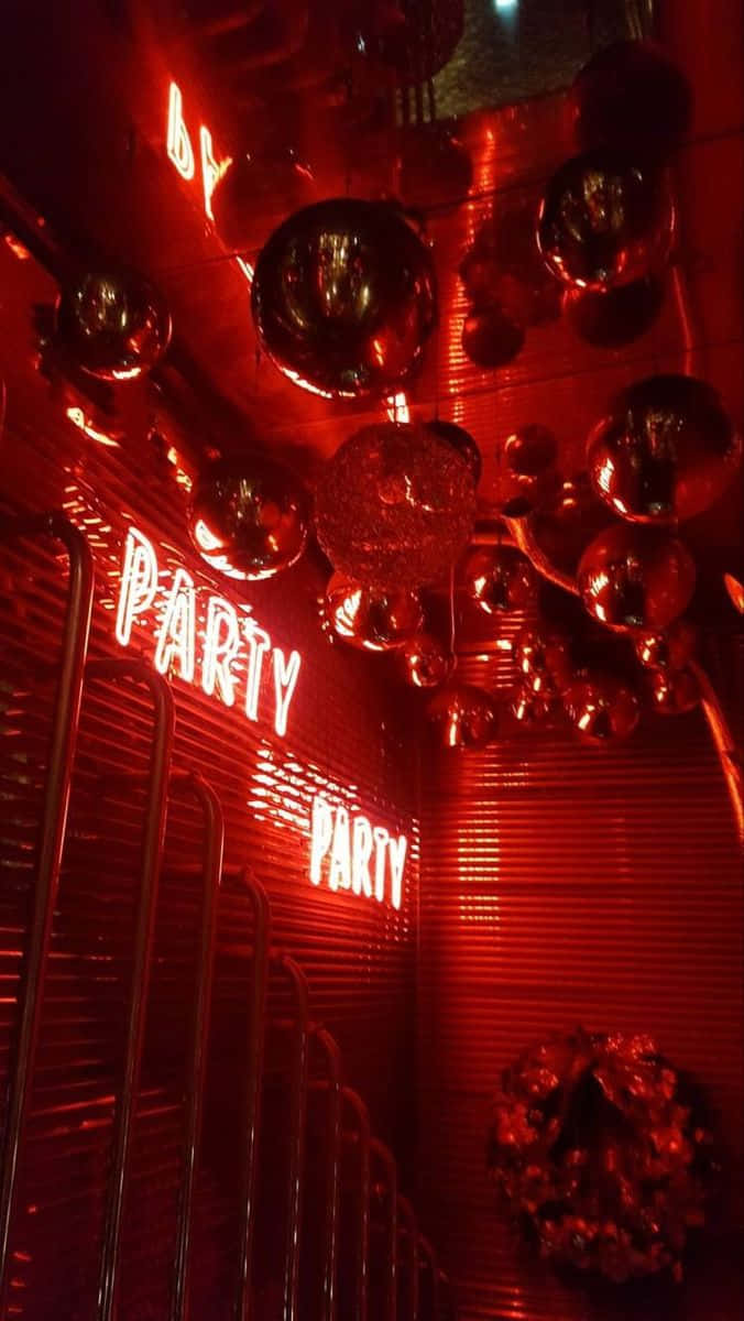  壁紙 — 充滿活力的紅色霓虹燈俱樂部入口，裝飾著懸掛的迪斯科球和發光的「PARTY」標誌。