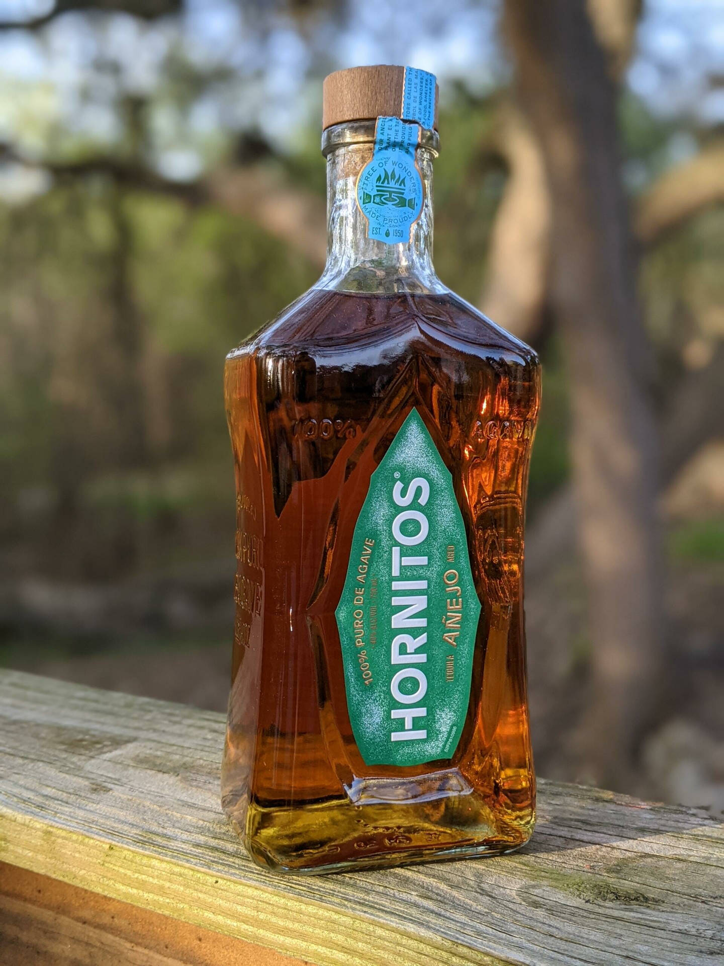 戶外木質表面上的Hornitos Añejo龍舌蘭酒瓶