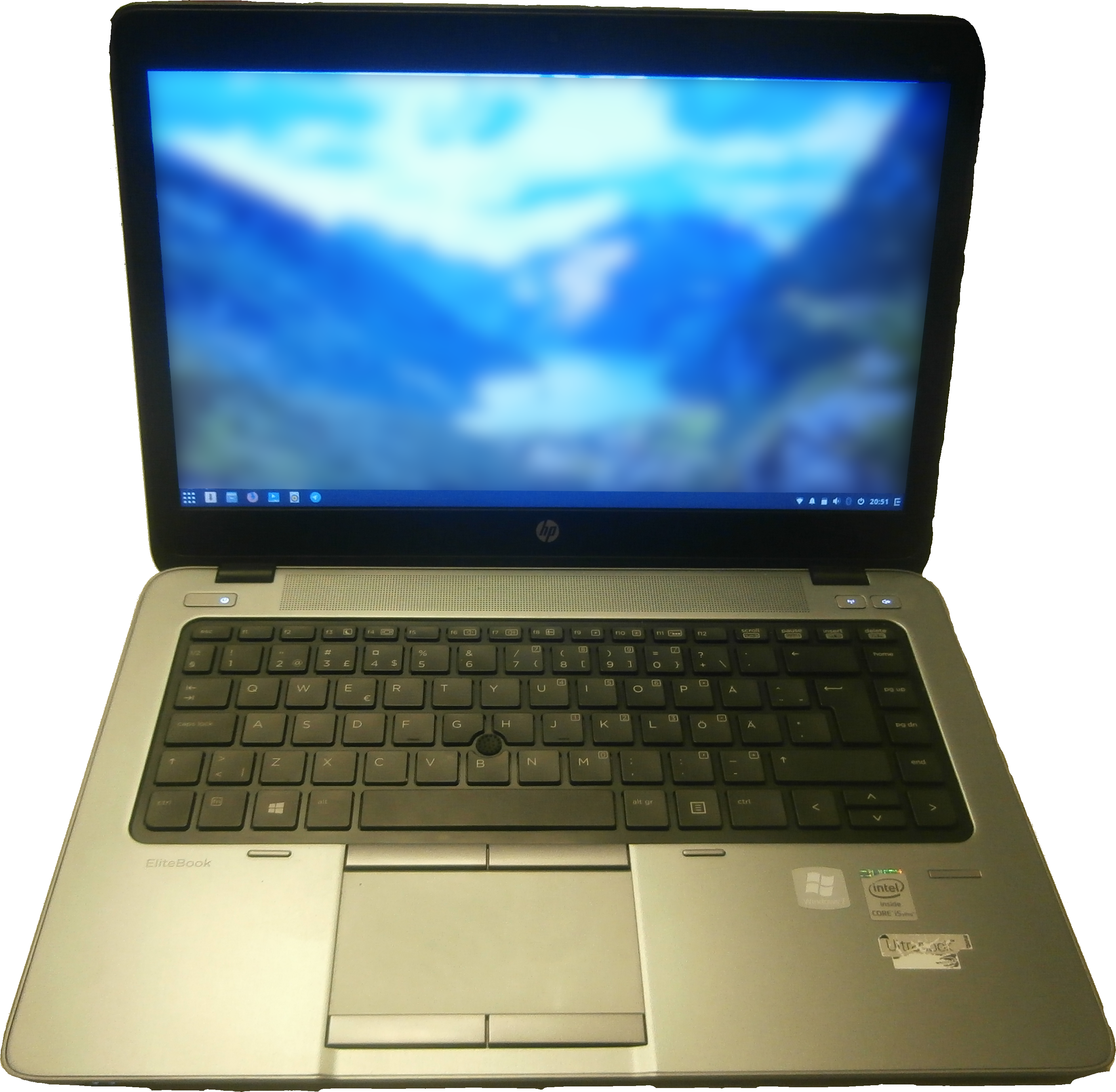 HP EliteBook 筆記型電腦打開狀態 壁紙 — 銀色 HP EliteBook 手提電腦在黑色背景前打開，顯示藍色山脈壁紙。
