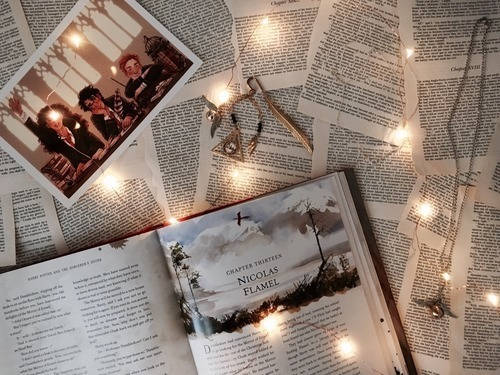 打開的書，帶有仙女燈和照片，放在報紙頁面上