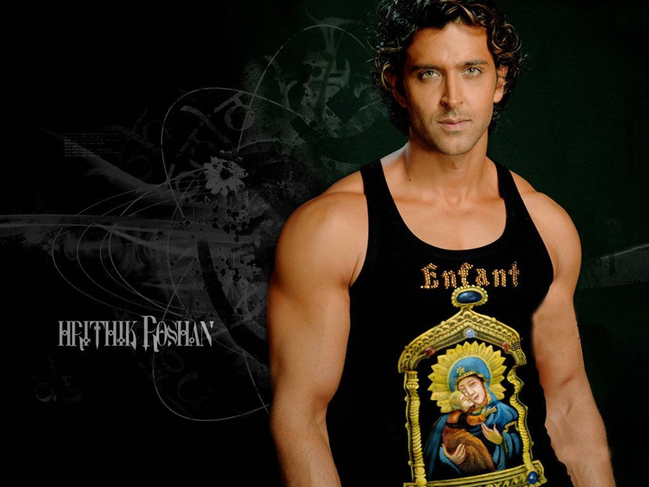 Hrithik Roshan 身穿黑色背心，帶有宗教圖案，背景深色。