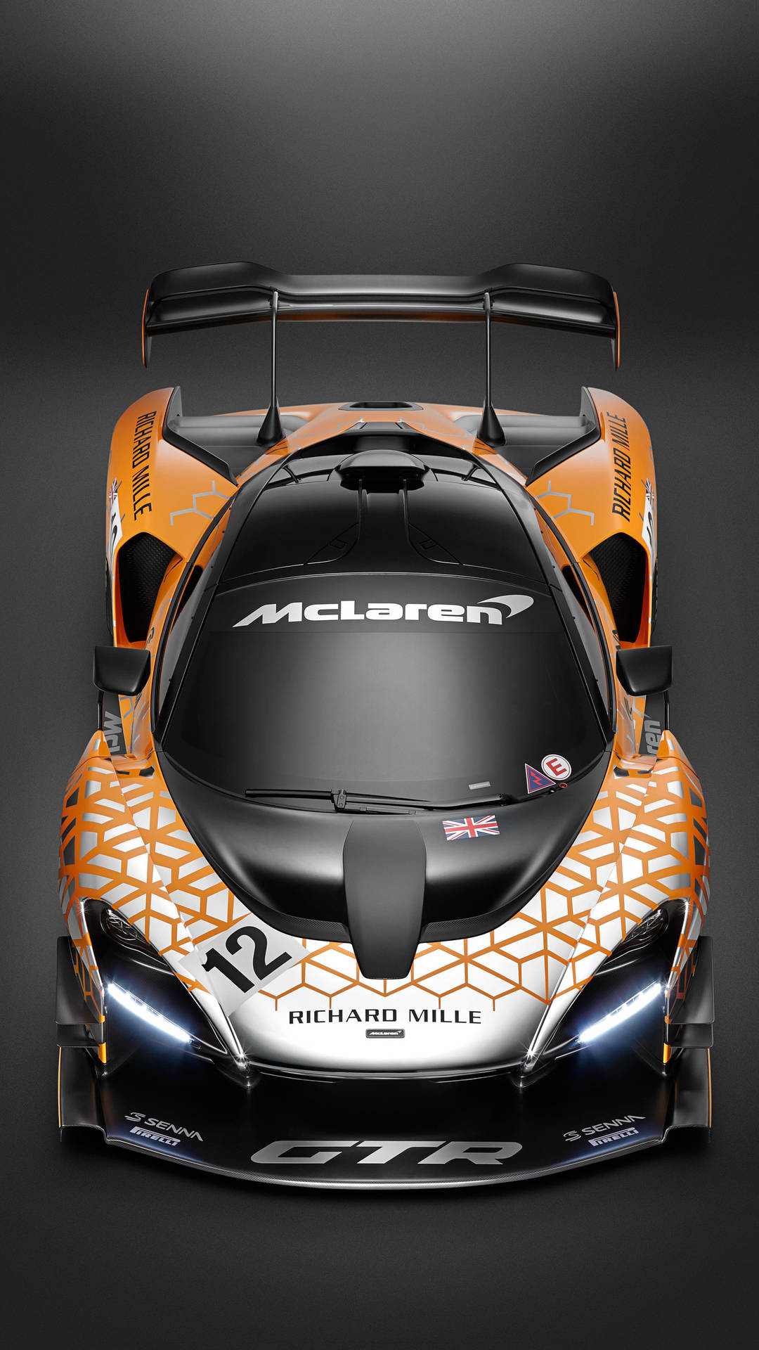 在黑暗的攝影棚中從上方看到的橙色和黑色McLaren Senna GTR賽車。