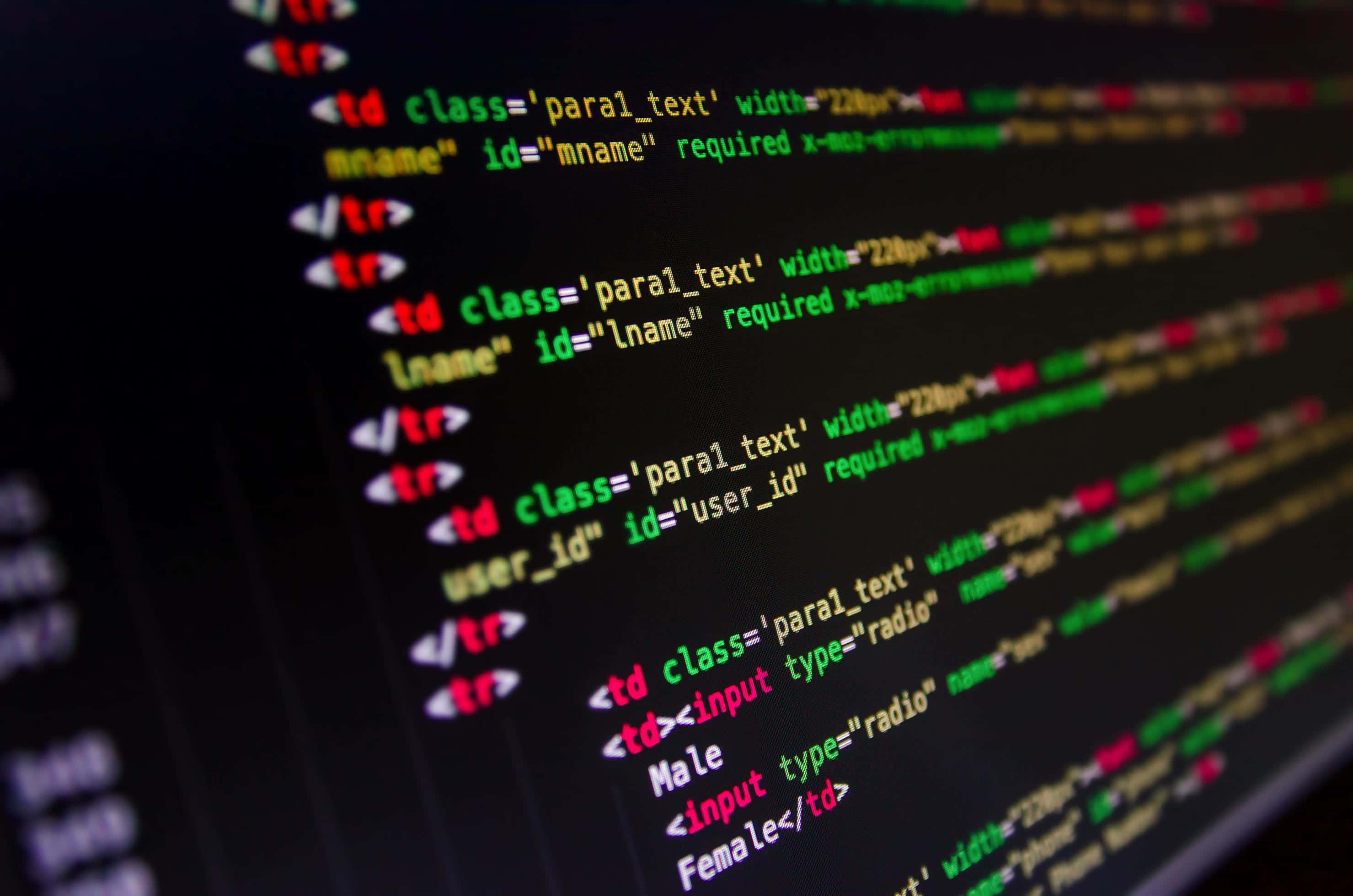 HTML 電腦程式碼 壁紙 — 發光彩色HTML和CSS代碼行在黑暗屏幕上的特寫，淺景深。