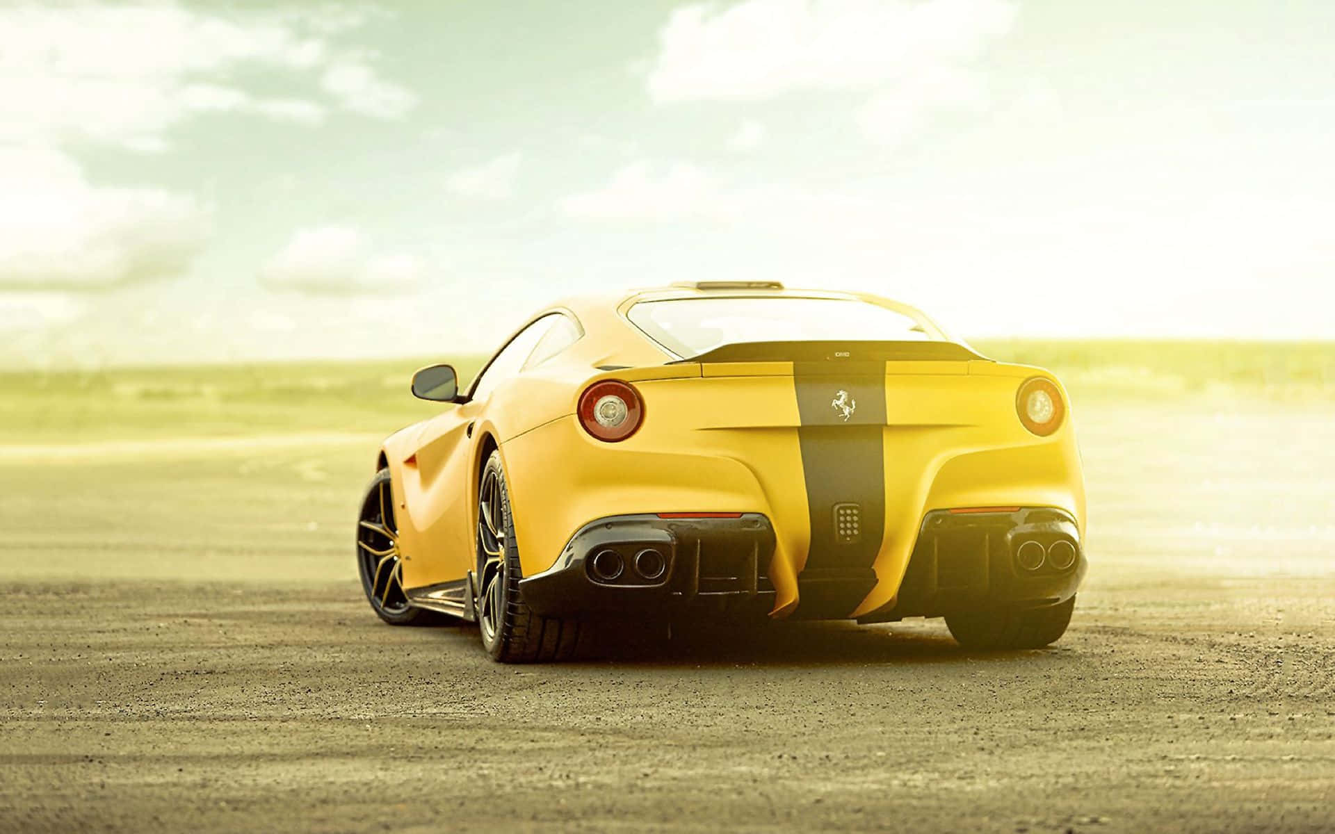 Ferrari F12 Berlinetta 桌布 壁紙 — 一輛充滿活力的黃色法拉利跑車帶有黑色賽車條紋，在朦朧的天空下，停在陽光明媚的沙漠賽道上。