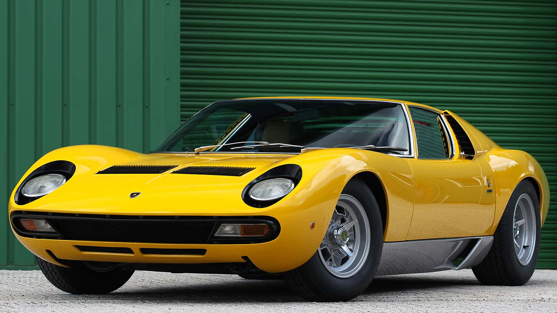 Lamborghini Miura 桌布 壁紙 — 一輛充滿活力的黃色林寶堅尼Miura跑車在日光下閃閃發光，背景是綠色波紋金屬板。