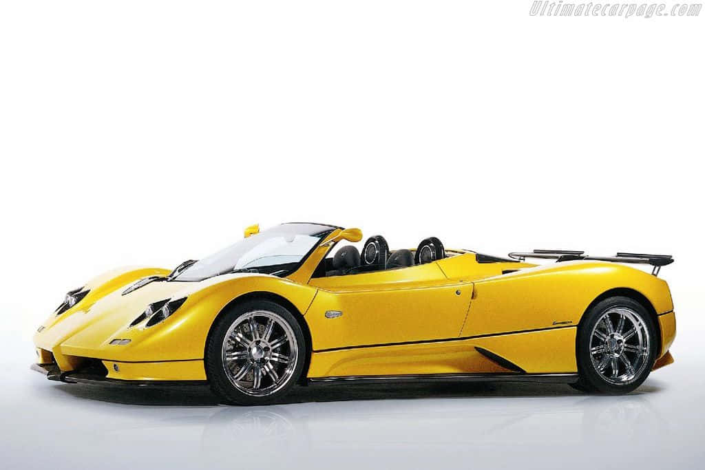 Pagani Zonda C12 Roadster 桌布 壁紙 — 一輛充滿活力的黃色Pagani Zonda開篷跑車，帶有黑色飾邊和鉻合金輪圈，矗立在潔淨的白色工作室環境中。