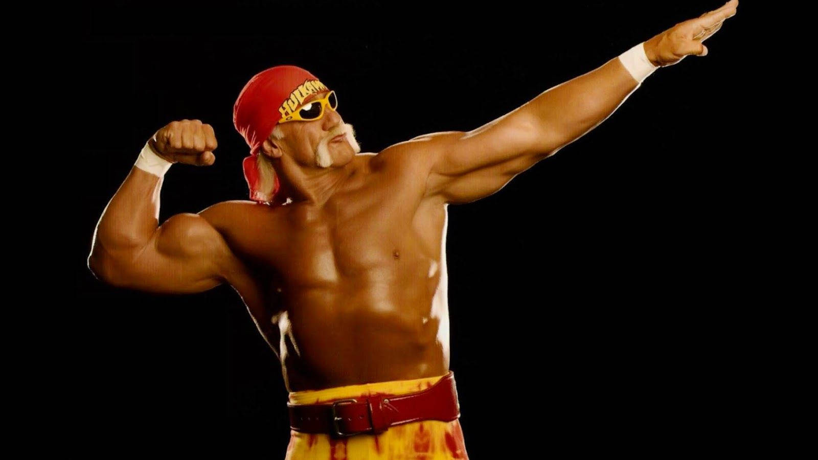 Hulk Hogan 超人姿勢 壁紙 — Hulk Hogan 在黑色背景前擺出戲劇性姿勢，繃緊肌肉並向前指。