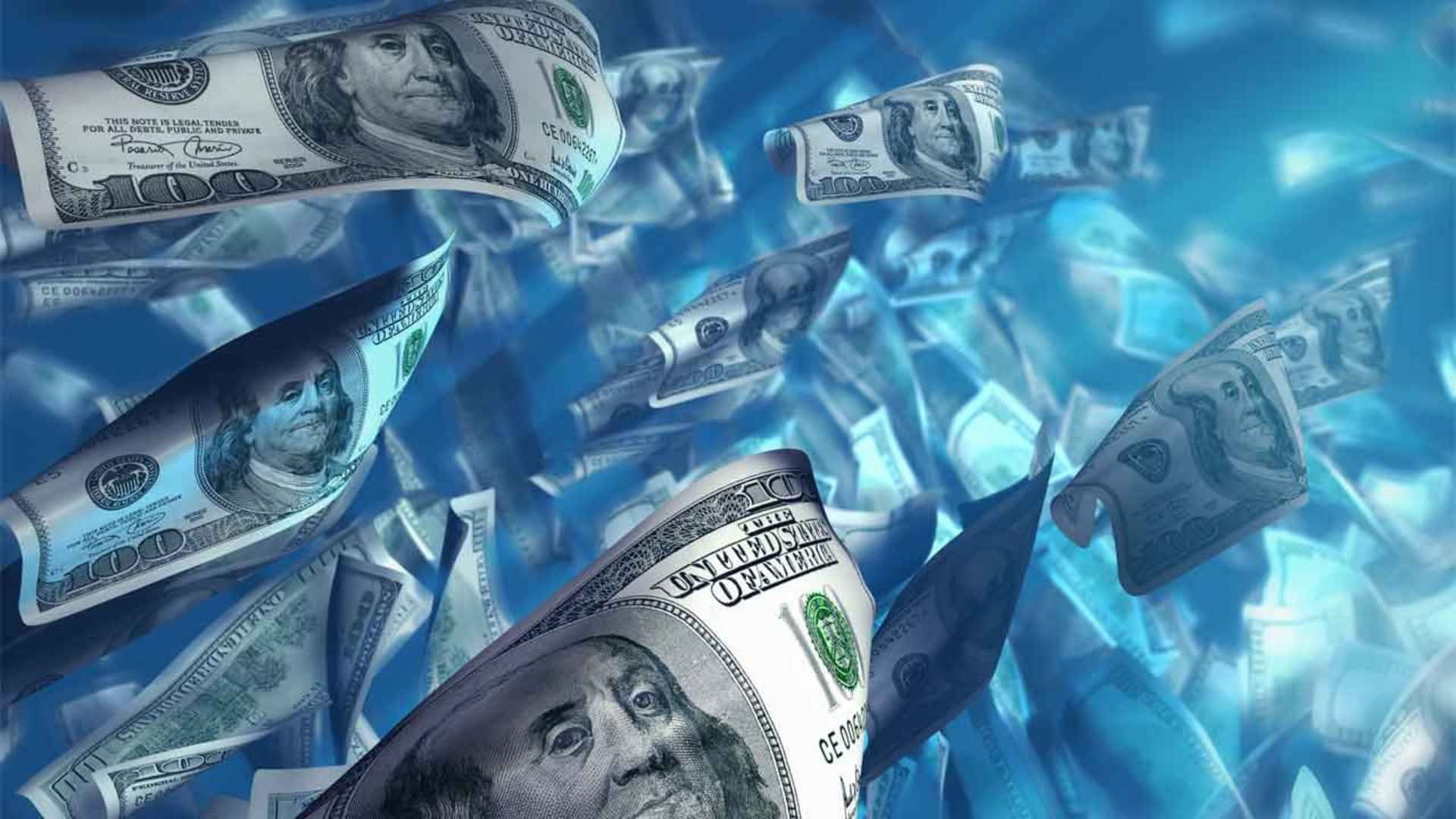  壁紙 — 一百美元鈔票在鮮豔的藍色背景上動態旋轉，構成數位藝術作品。