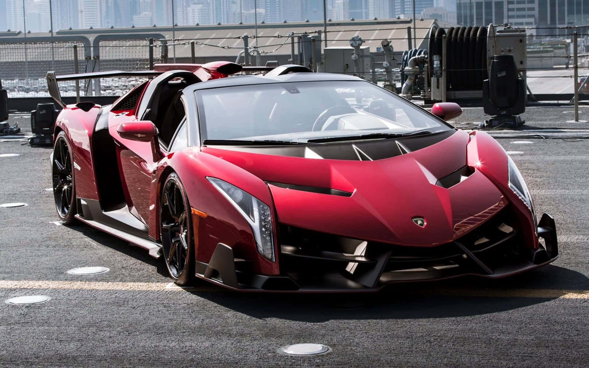 Lamborghini Veneno 桌布 壁紙 — 一架搶眼的紅色林寶堅尼 Veneno 開篷跑車停泊在天台上，背景是城市天際線。