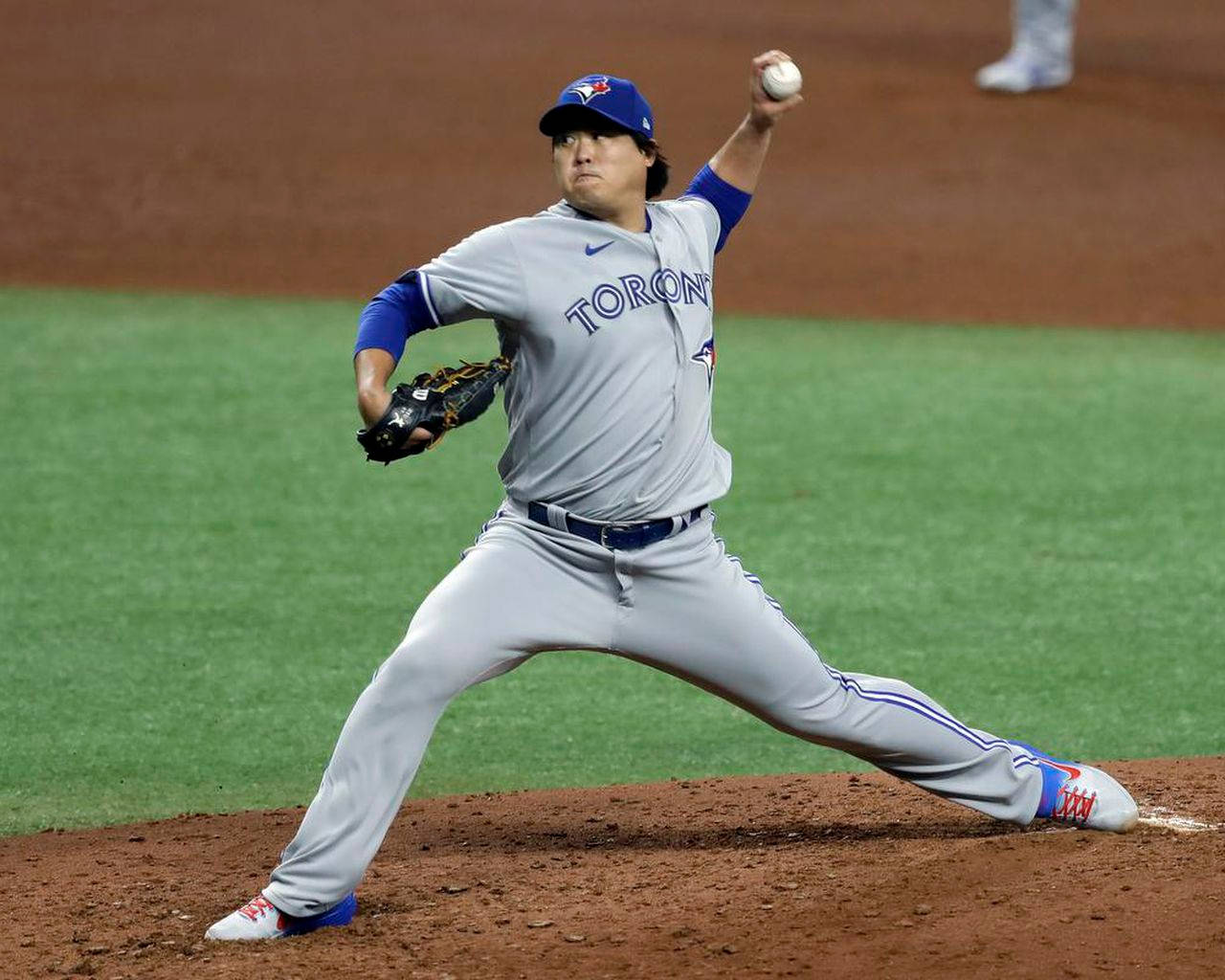 棒球投手在夜間燈光球場上投球中。