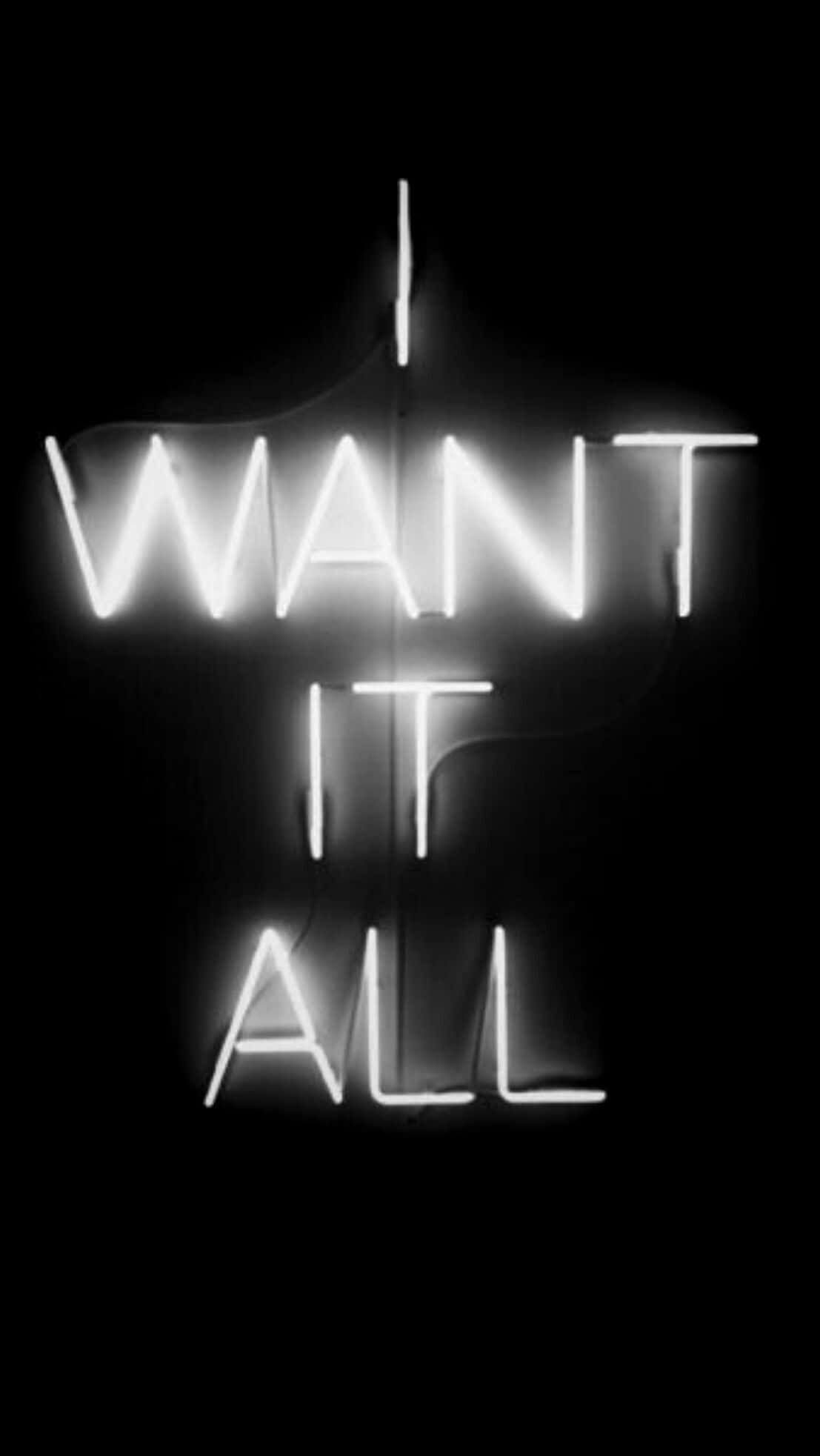 白色霓虹燈「I Want It All」 壁紙 — 一個發光的白色霓虹燈牌在漆黑的背景上拼出「I WANT IT ALL」，並帶有可見的煙霧。