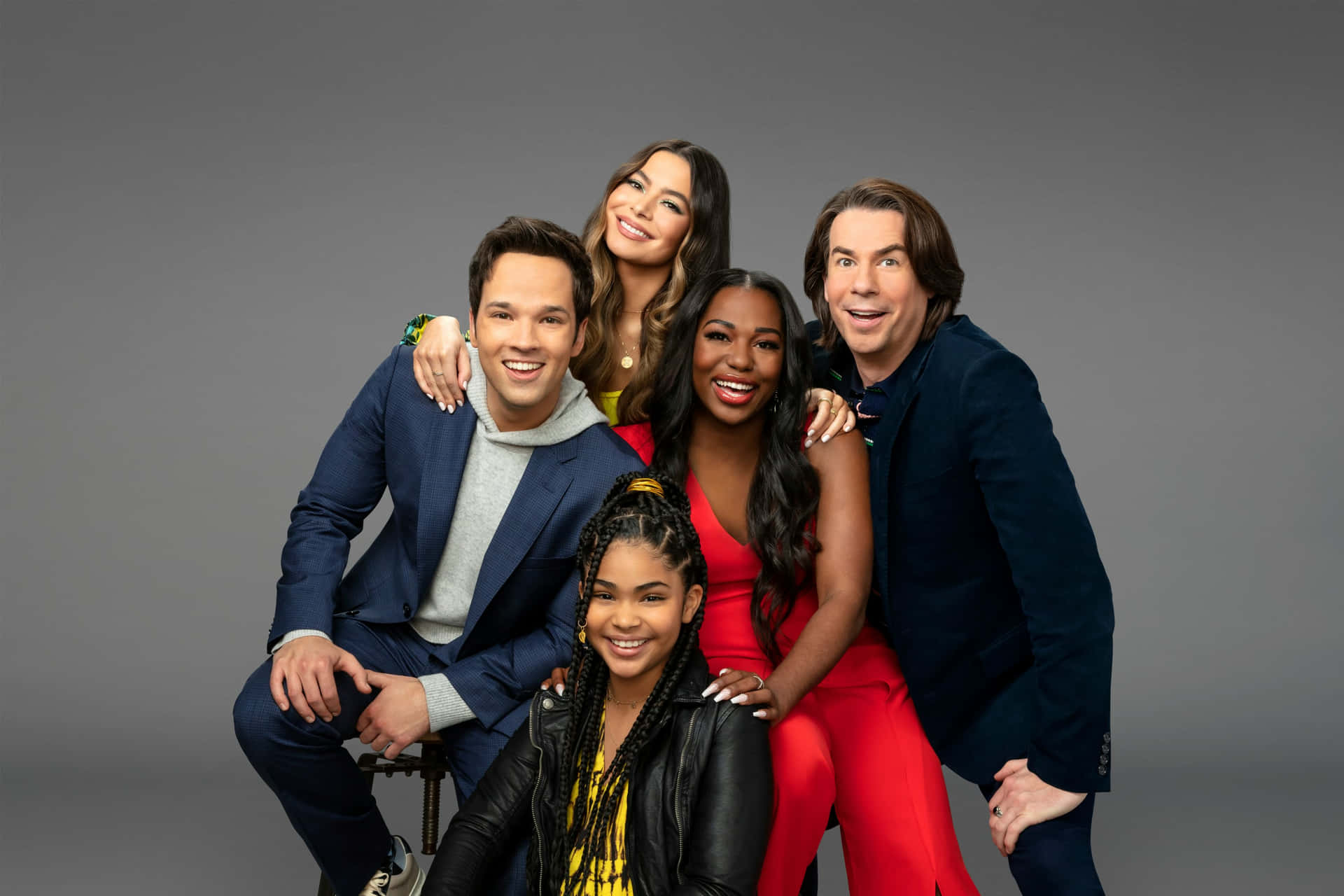iCarly 演員重聚肖像 壁紙 — 五位微笑的演員在樸素的灰色工作室背景下，穿著時尚的現代服裝緊密地擺姿勢。