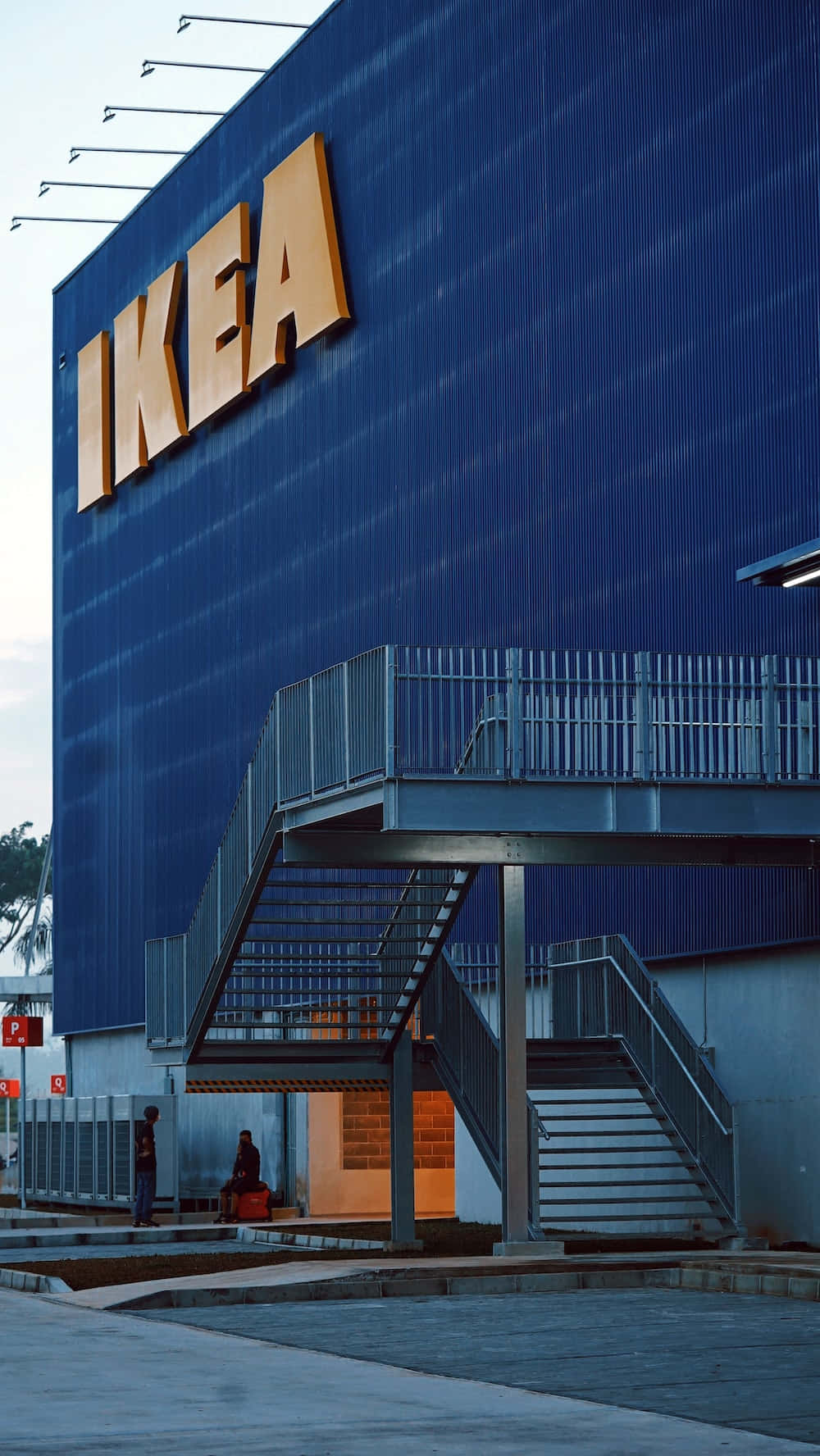 藍色 IKEA 商店，黃色標誌和金屬樓梯，黃昏時分。